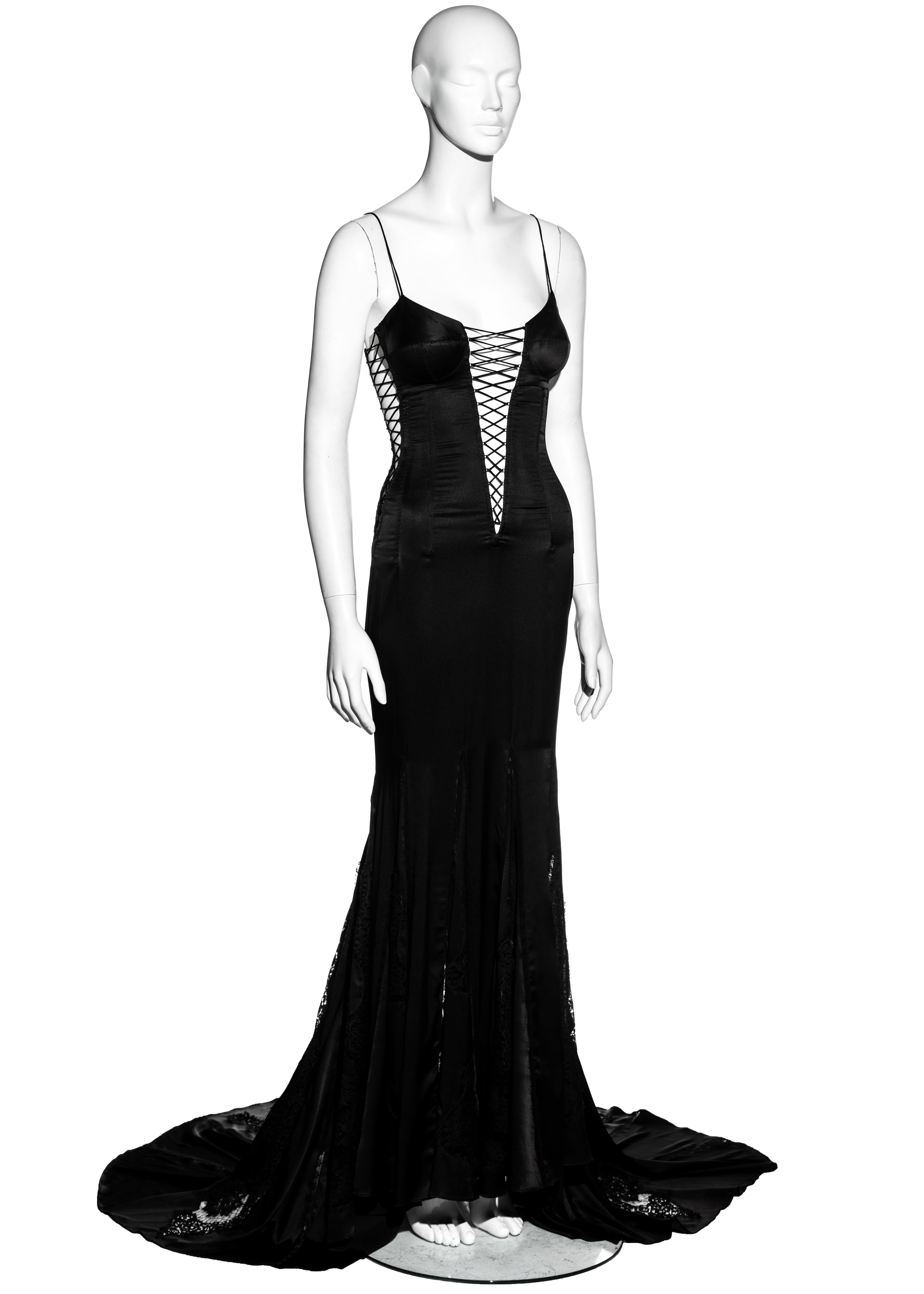 ▪ Dolce & Gabbana Abendkleid aus schwarzer Seide 
▪ Mieder mit Korsett
▪ Dreieckiger:: hautfreier Ausschnitt mit Kreuzschnürung
▪ Spaghettiträger
▪ Eingebauter:: gepolsterter BH 
▪ Schleppenrock mit Spitzeneinsätzen 
▪ Das Design wurde erstmals von