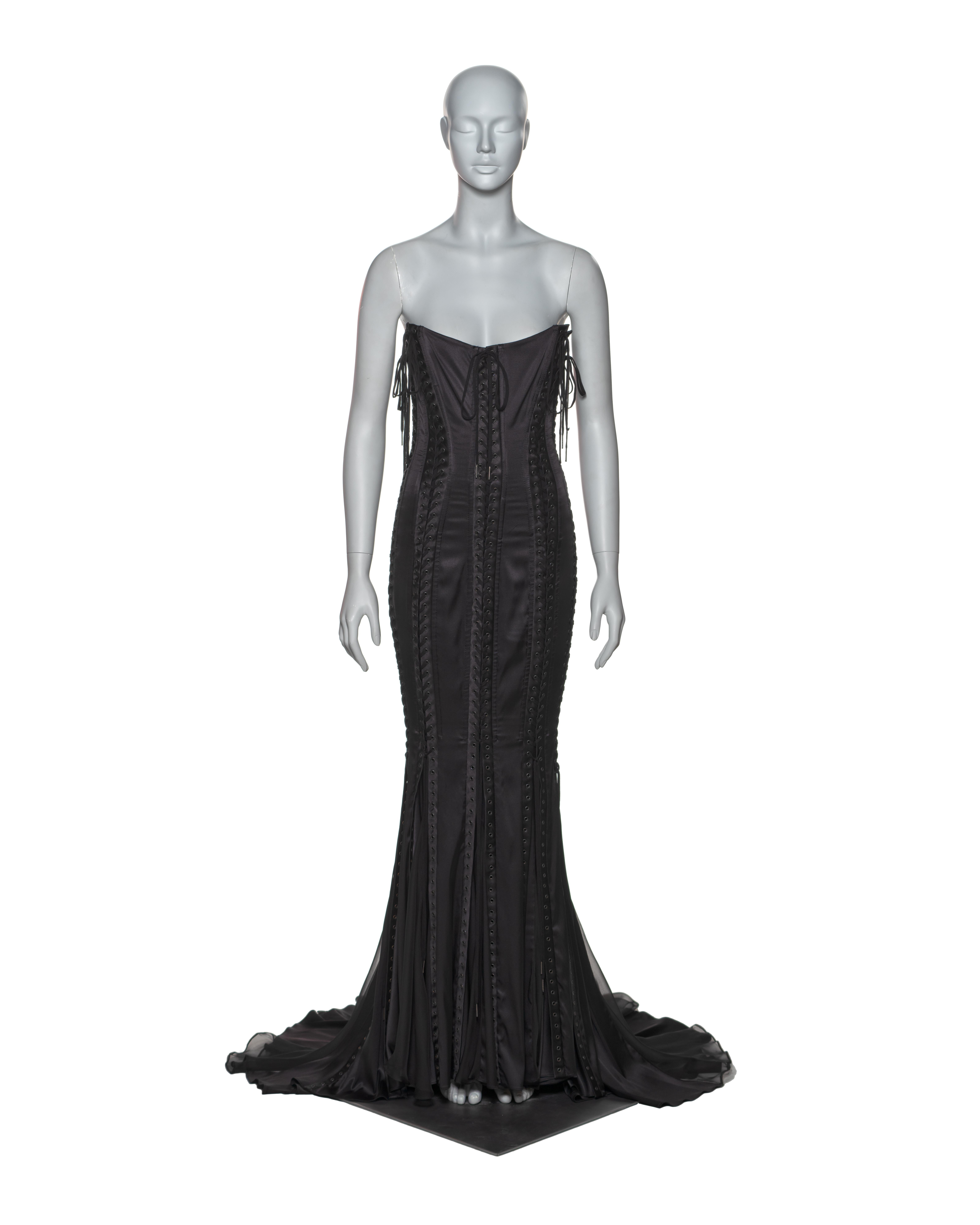 This Dolce & Gabbana evening dress features a strapless corset bodice with adjustable ribbon lacing and a fishtail hem. Crafted from black silk, the dress is accentuated with panels of flowing silk chiffon at the hem and train. 

▪ Brand: Dolce &