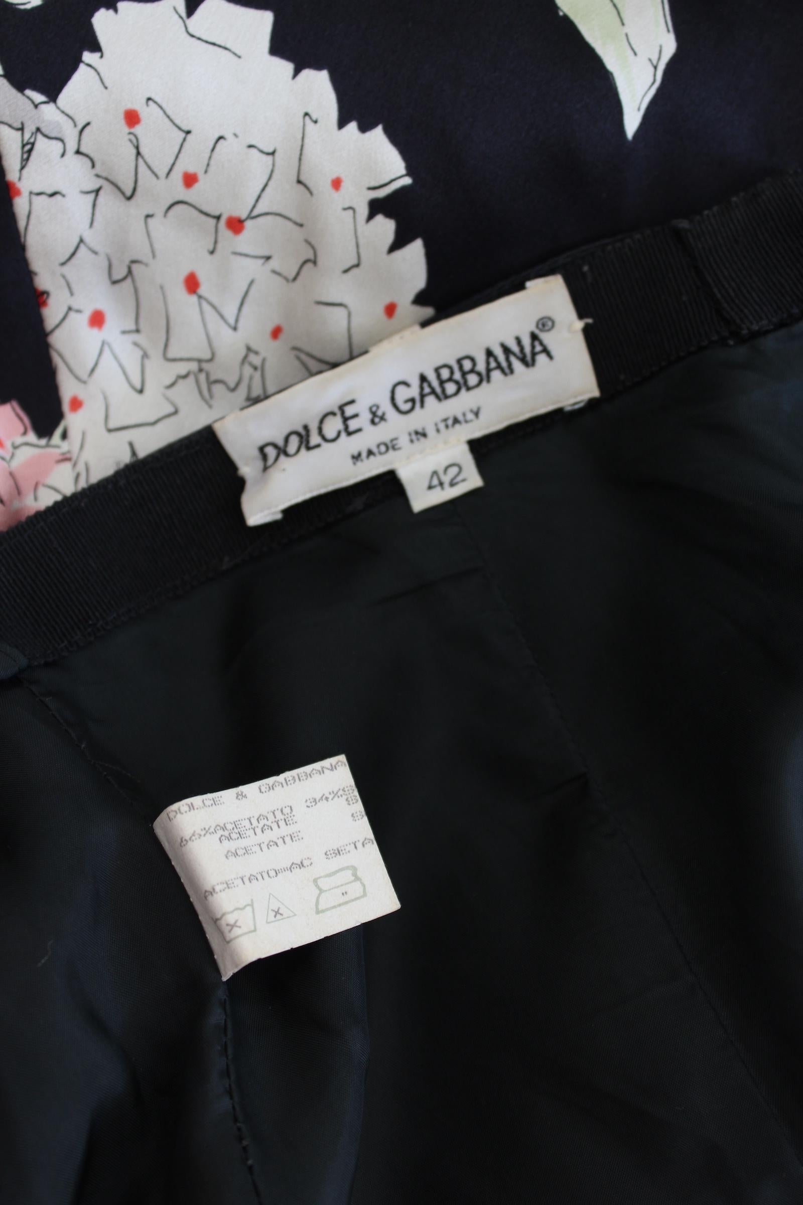 Dolce & Gabbana elegant 2000s floral dress. Short dress, sleeveless, halter neckline, flared skirt. Black background color with pink, beige and red floral pattern. Zip closure on the skirt. Composition 66% acetato, 34% silk. Made in Italy.

Size: 42