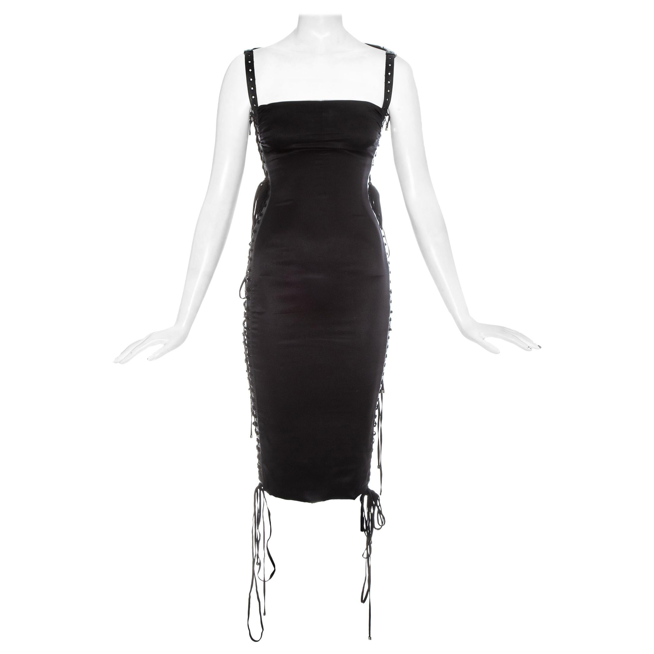 Dolce & Gabbana; black silk spandex figure hugging evening dress. 

- Lambskin leather grommet trim 
- Open on both sides with lace up fastenings
- Invisible side zip closure 

Spring-Summer 2003

*due to the lace up fastenings the dress can be worn