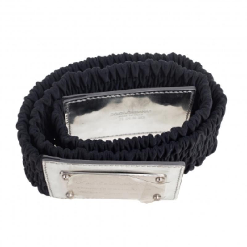 A classic add-on to your collection of belts, this Dolce & Gabbana belt has been crafted from patent leather and elasticised fabric in Italy. It has a lovely black shade and a square silver-tone buckle with an engraved brand name. This piece carries