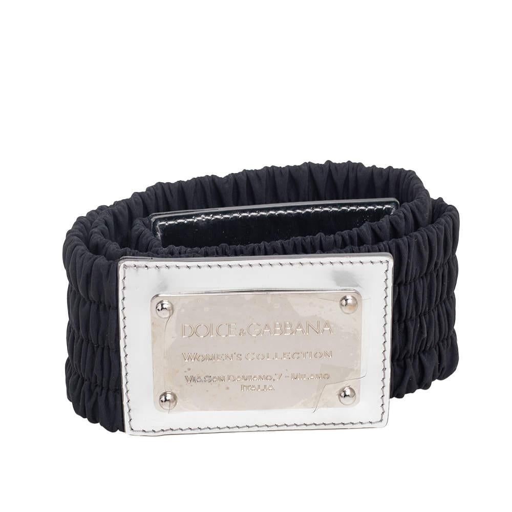 A classic add-on to your collection of belts, this Dolce & Gabbana belt has been crafted from patent leather and elasticised fabric in Italy. It has a lovely black shade and a square silver-tone buckle with an engraved brand name. This piece carries