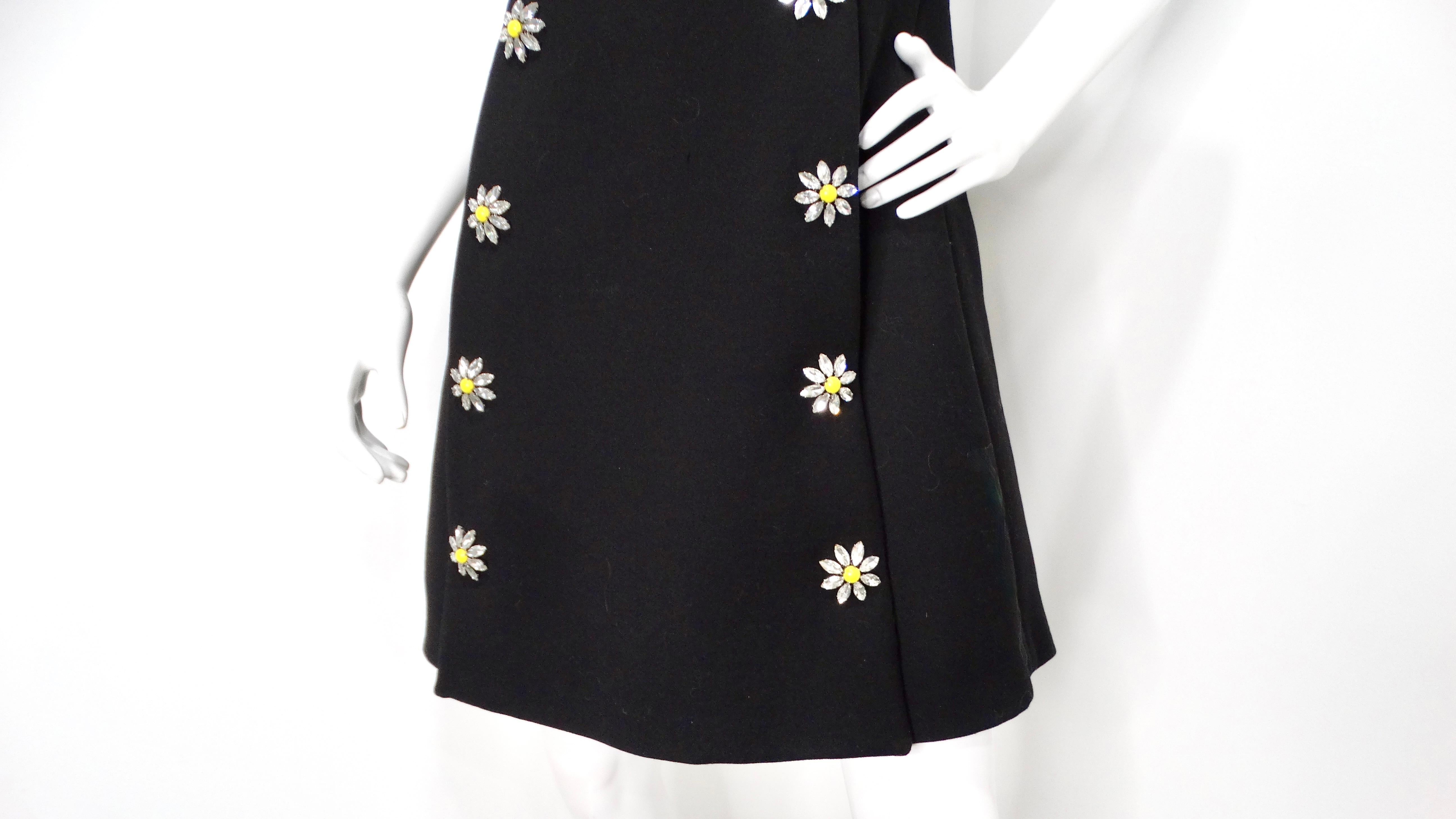 The Dolce & Gabbana Black Sleeveless Dress with Daisy Crystal Accents epitomizes elegance and playful sophistication. This charming black dress gently cinches at the waist to accentuate your silhouette before flaring out at the bottom, creating a