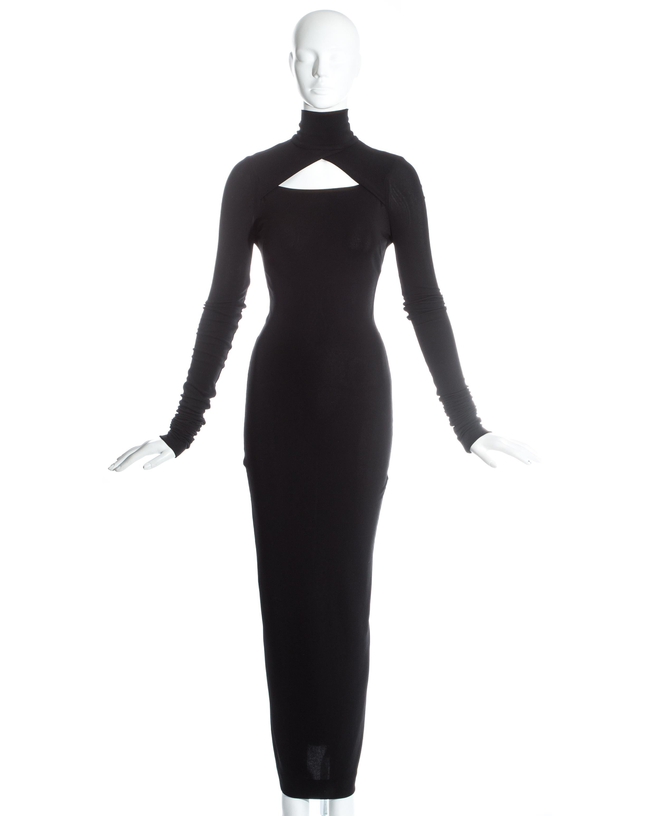 Dolce & Gabbana black spandex figure hugging maxi dress with cut out, turtle neck, zip fastening, and pleating down the centre back. 

c. 1990s