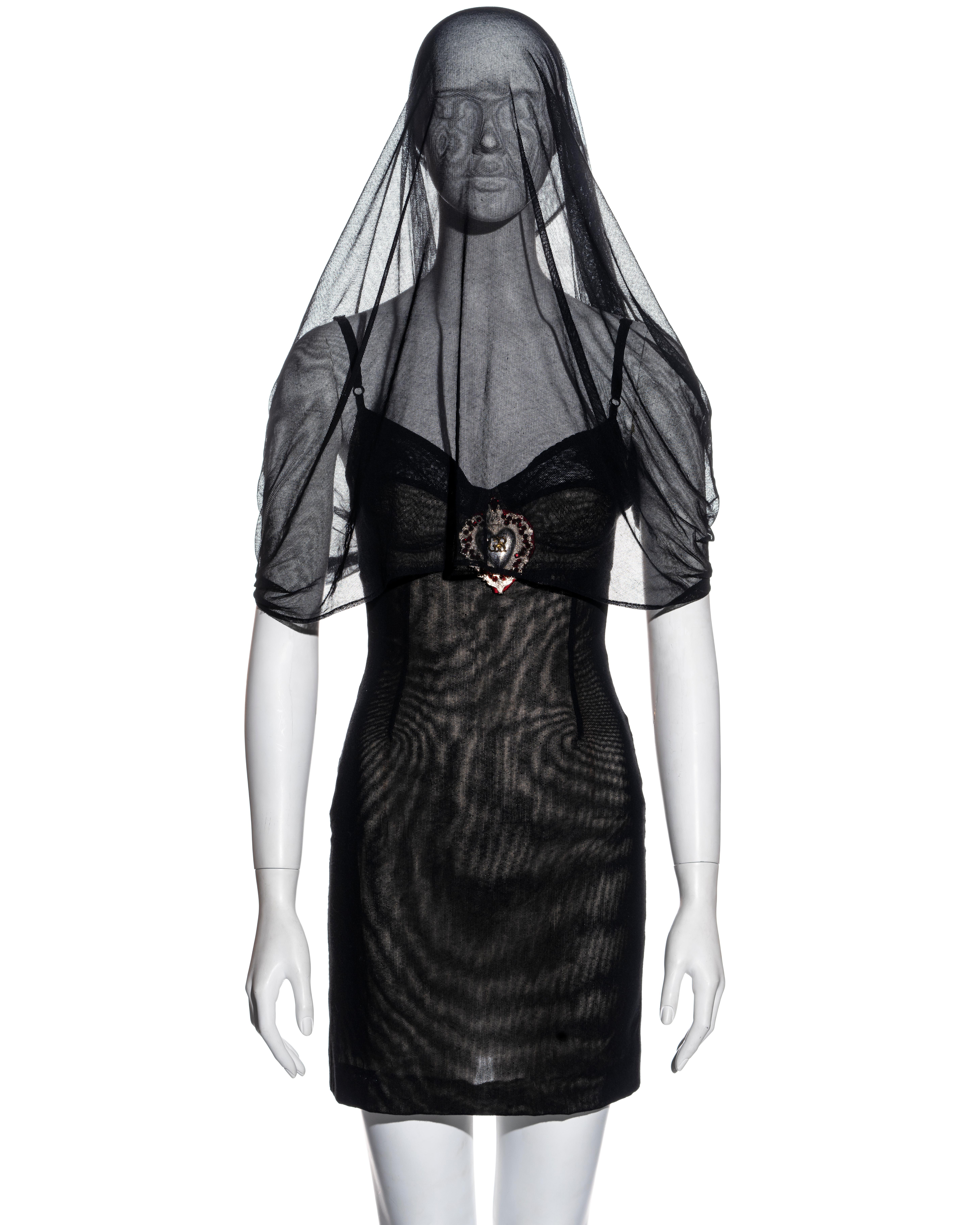 ▪ An important Dolce & Gabbana veiled mini dress
▪ Black double-layer stretch cotton tulle
▪ Attached veil; can be worn in many ways 
▪ Corset hooks at back opening
▪ Built-in bra 
▪ Large heart-shaped pendant with red crystals
▪ IT 42 - FR 38 - UK