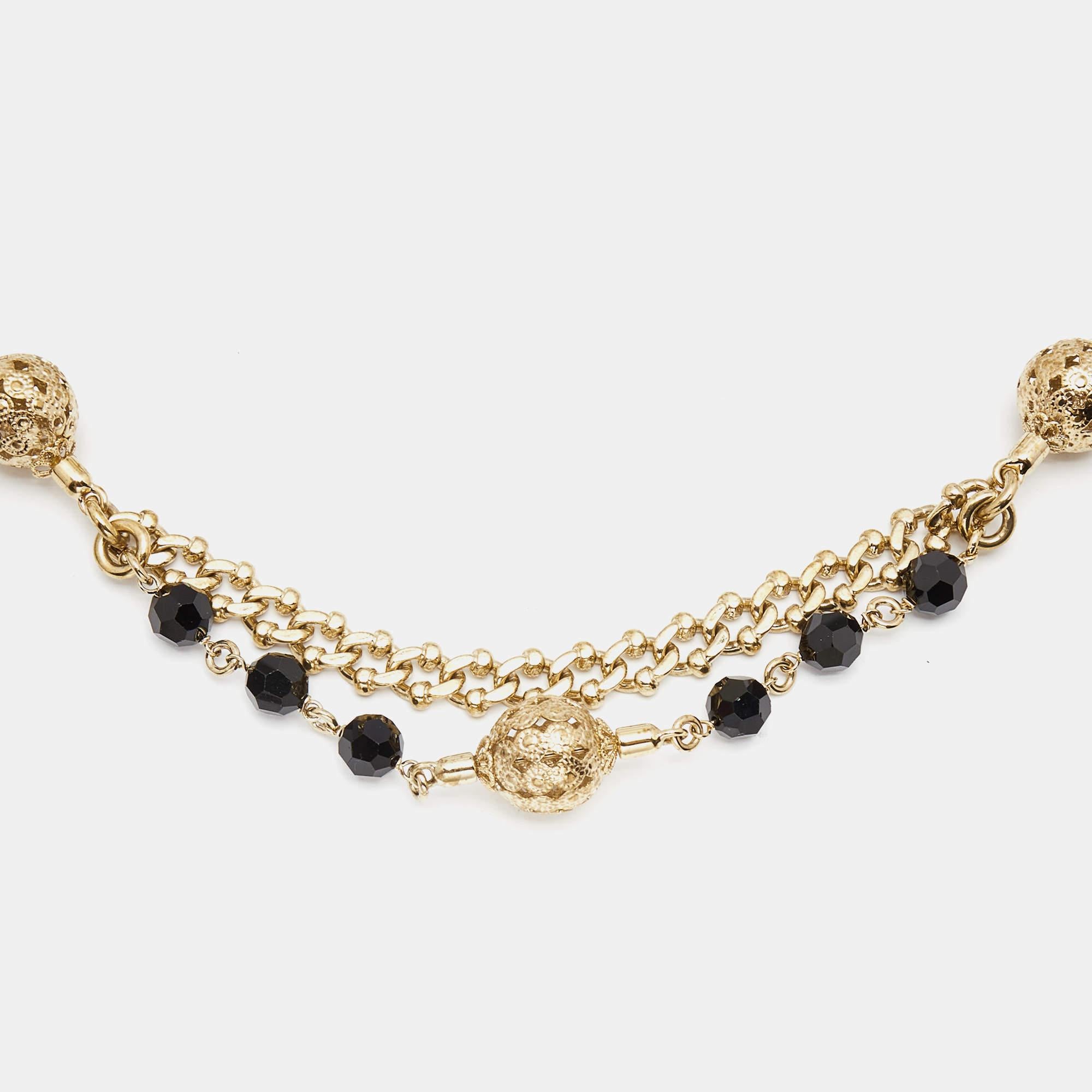 Made from black suede, it features a gold tone chain adorned with delicate beads. The belt adds a touch of elegance and glamour to any outfit, whether worn with jeans or a dress. It is a versatile piece that effortlessly enhances your waistline and