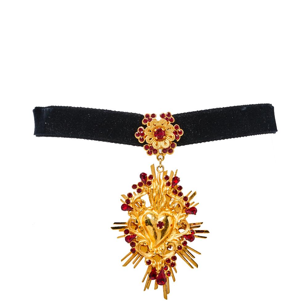 This Dolce & Gabbana choker necklace will style up your off-shoulder tops and dresses. The stunning necklace has a romantic vibe with a D&G spin. A black velvet ribbon holds an ornate gold-tone heart pendant set with crystals. The unique shape and