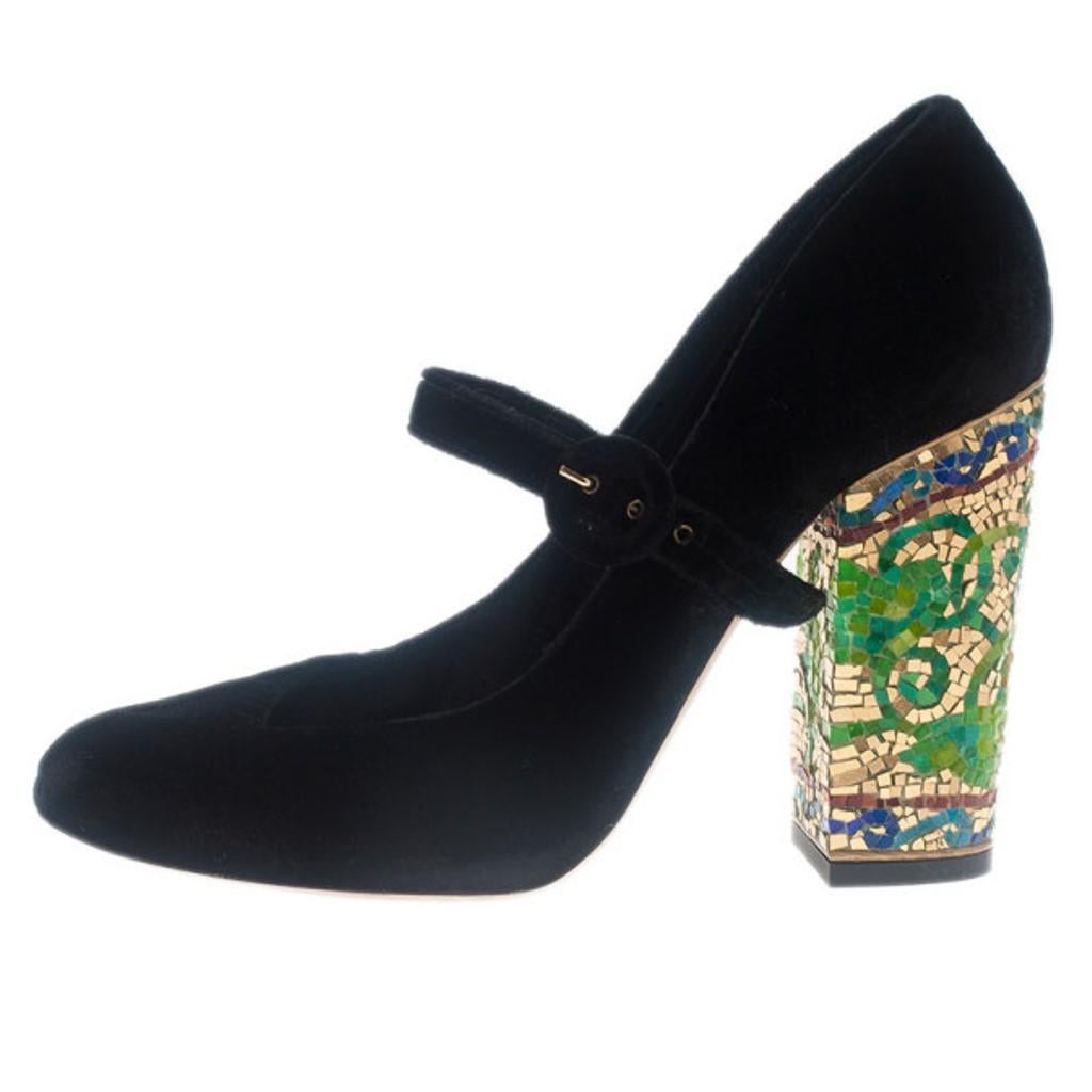 These Dolce and Gabbana Mary Jane Pumps will add character to any outfit! Made from soft black colored velvet, they feature straps across their vamps. They have chunky 11cm heels that are embellished with colorful mosaic-like designs. Lined with