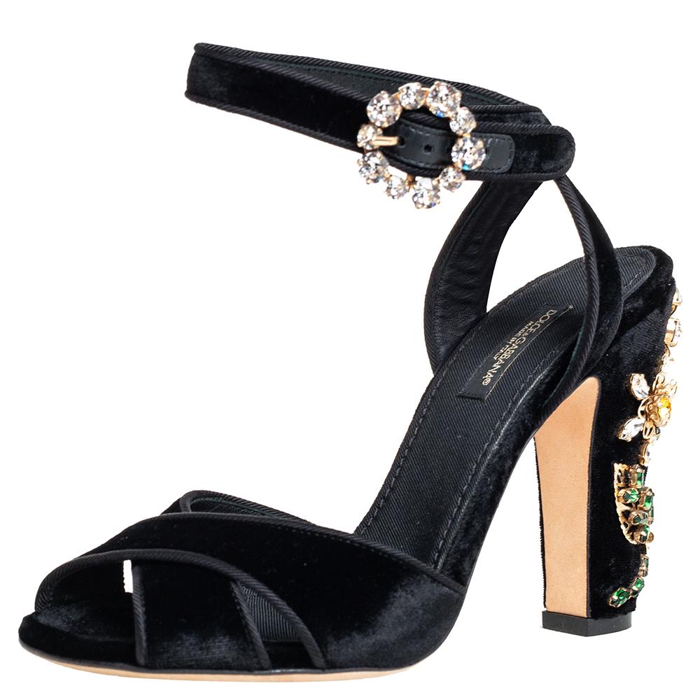 You'll love these velvet sandals from Dolce & Gabbana as they bring a dazzling appeal. They flaunt open toes, crystal-embellished buckle ankle fastening, and 11 cm heels decorated with blooming crystal flowers. The black sandals are just perfect to