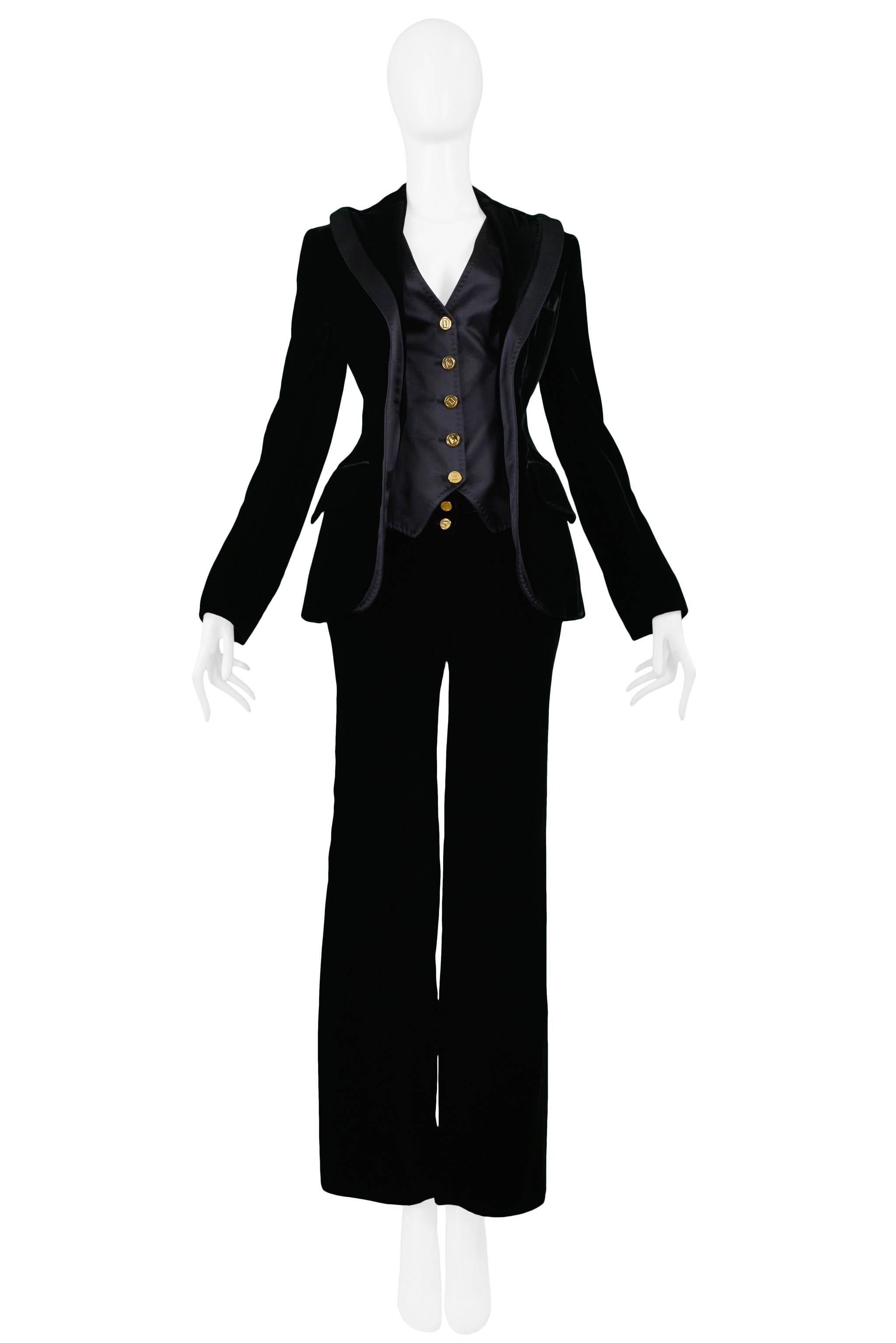 Resurrection Vintage is excited to offer a vintage Dolce & Gabbana black velvet tuxedo ensemble. The suit features a fitted black velvet jacket with an attached black satin vest, satin trim, flap pockets, and skinny sleeves with gold buttons. The