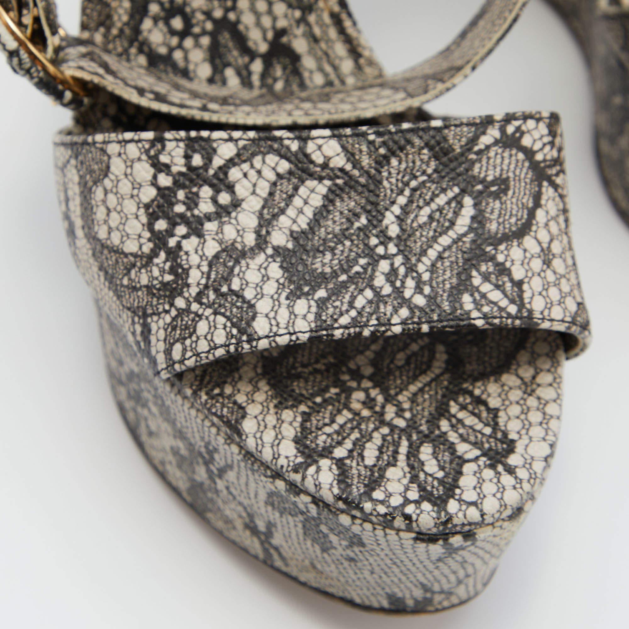 Diese Sandalen von Dolce & Gabbana fangen mit ihrer modernen Form die Eleganz einer Frau perfekt ein. Sie sind wunderschön aus Spitze gefertigt, haben einen auffälligen Druck und werden mit einer Schnalle am Knöchel geschlossen. Die Keilabsätze und