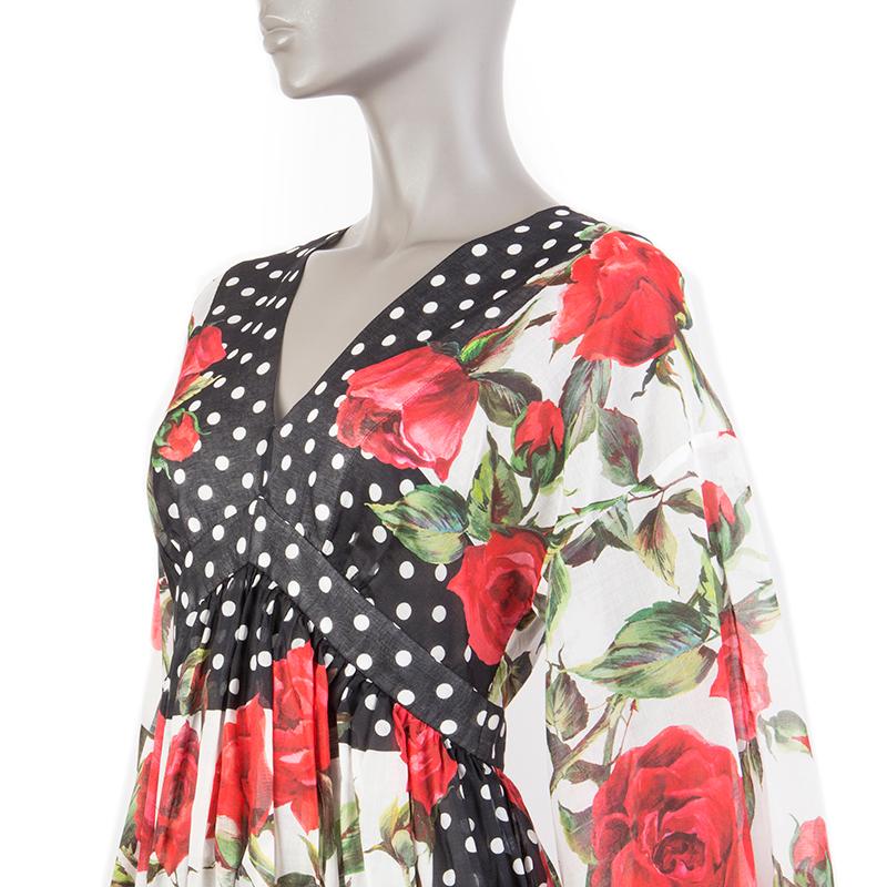 Dolce & Gabbana dotted rose empire dress in black, white, red, and green cotton voile (100%). With v neck and back, drop shoulders, gathered waist, and bell sleeves. Closes with concealed zipper on the back. Unlined. Has been worn and is in