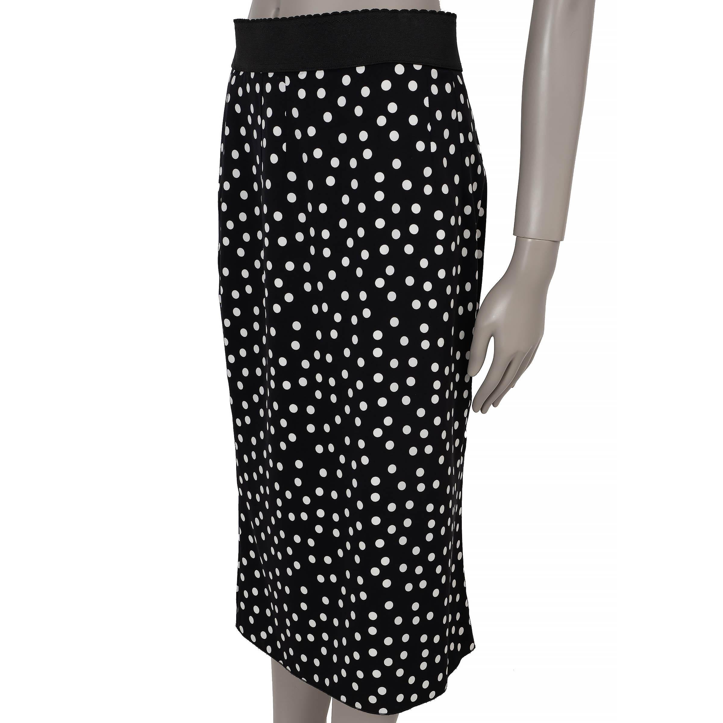 This 100% authentic Dolce & Gabbana skirt in black and white polka-dot printed silk (with 6% elastane) exudes vintage-inspired charm with a modern edge. Designed with a high-waisted, pencil silhouette and knee-length cut, it features a contrasting