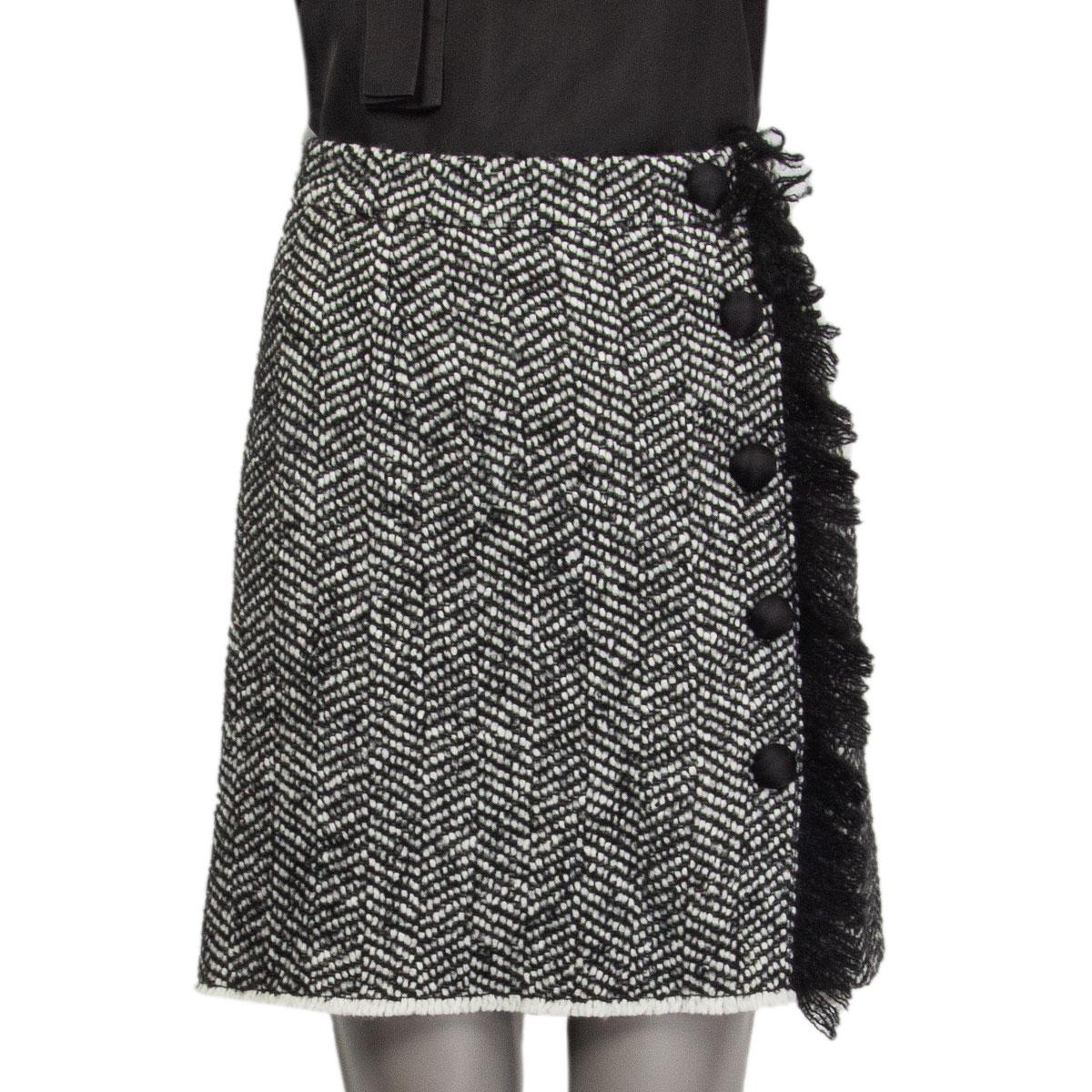 authentic Dolce&Gabbana bouclé A-line skirt in black&white wool (41%), acrylic (33%), polyester (13%), alpaca (10%) and polyamide (3%) with buttons and a wool fringe embellishment on the front. Closes with two buttons and a zip on the back. Lined in