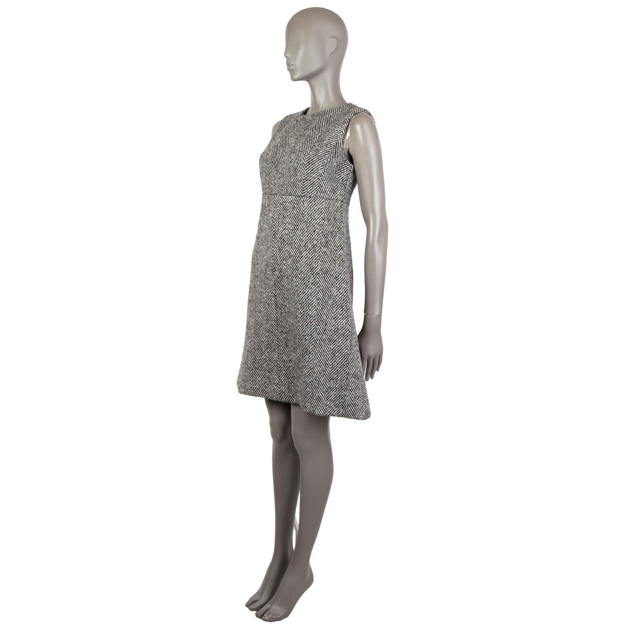 Dolce & Gabbana tweed dress in black and white wool (100%) with a classic herringbone pattern, A-line fit, round neckline, sleeveless, above knees. Unlined. Closes with a hook & bar and a concealed zipper in the back. Has been worn and is in