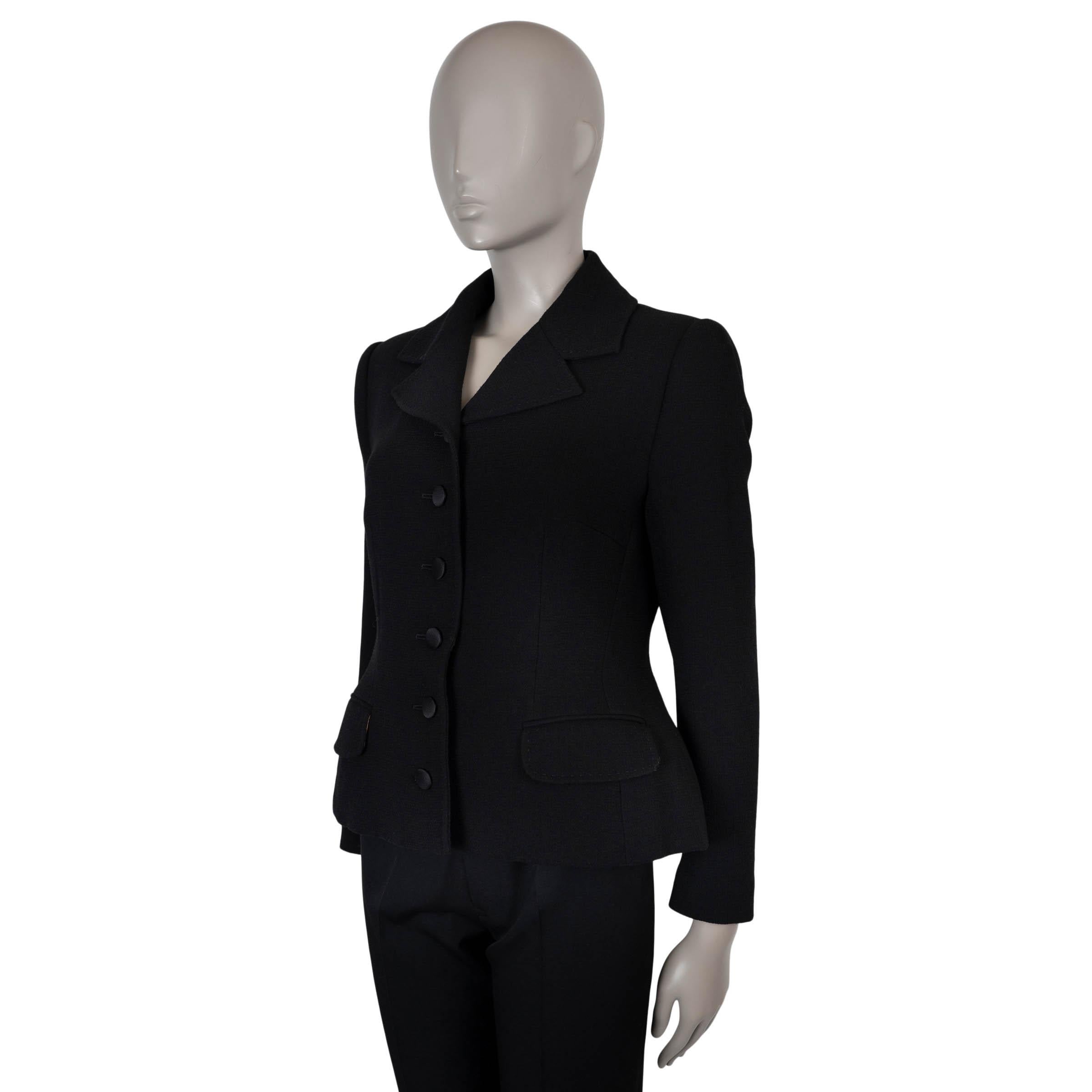 Questo blazer di Dolce & Gabbana, autentico al 100%, è realizzato in lana nera (100%) e ha una silhouette raffinata e aderente con una lunghezza leggermente ridotta. Presenta rever a punta, due tasche frontali con patta e bottoni rivestiti in