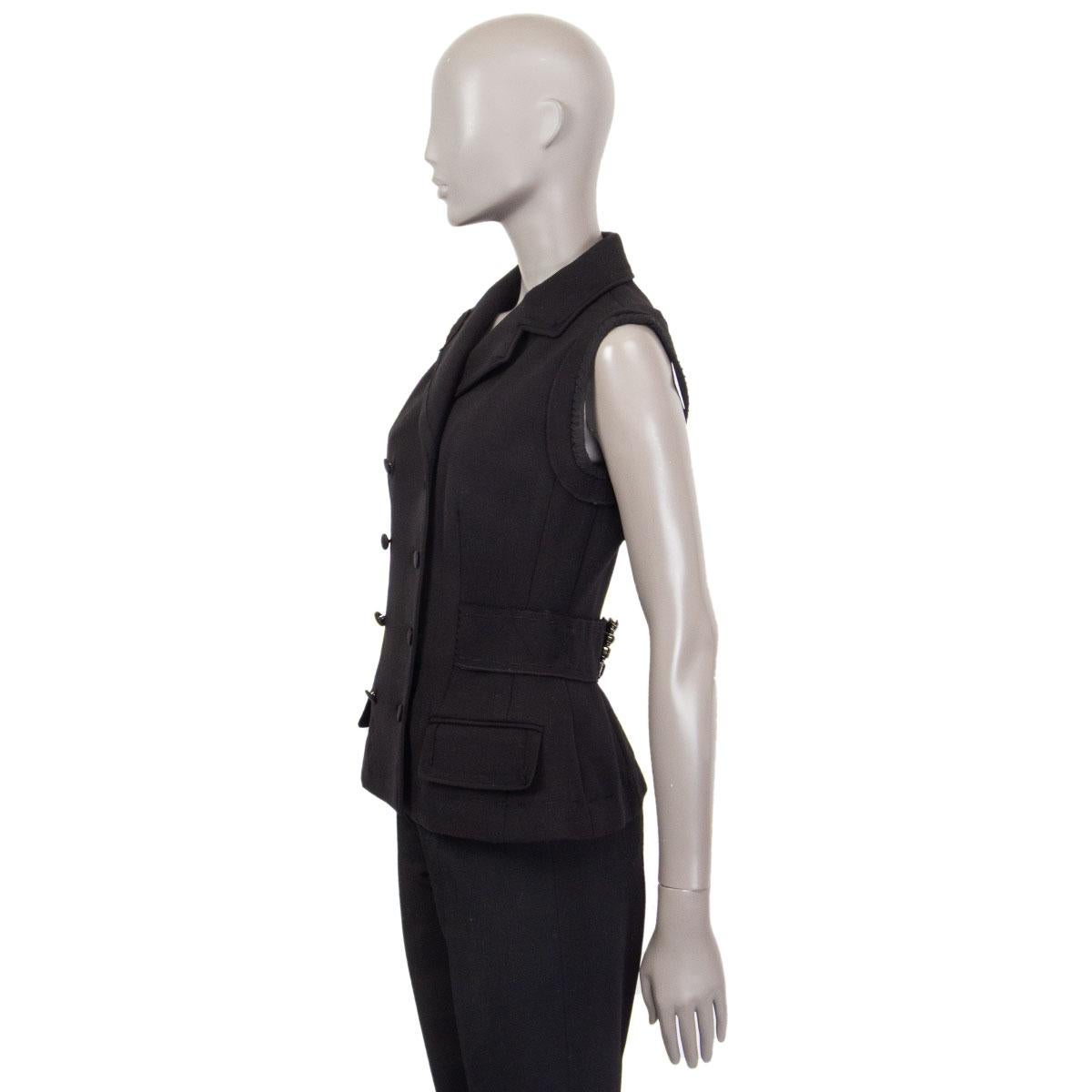 100% authentic Dolce & Gabbana double-breasted vest in black (probably wool blend) with stitching details, fringed hemline, notch collar, two flap pockets and a waist belt at the back with an embellished buckle. Closes with round black buttons in