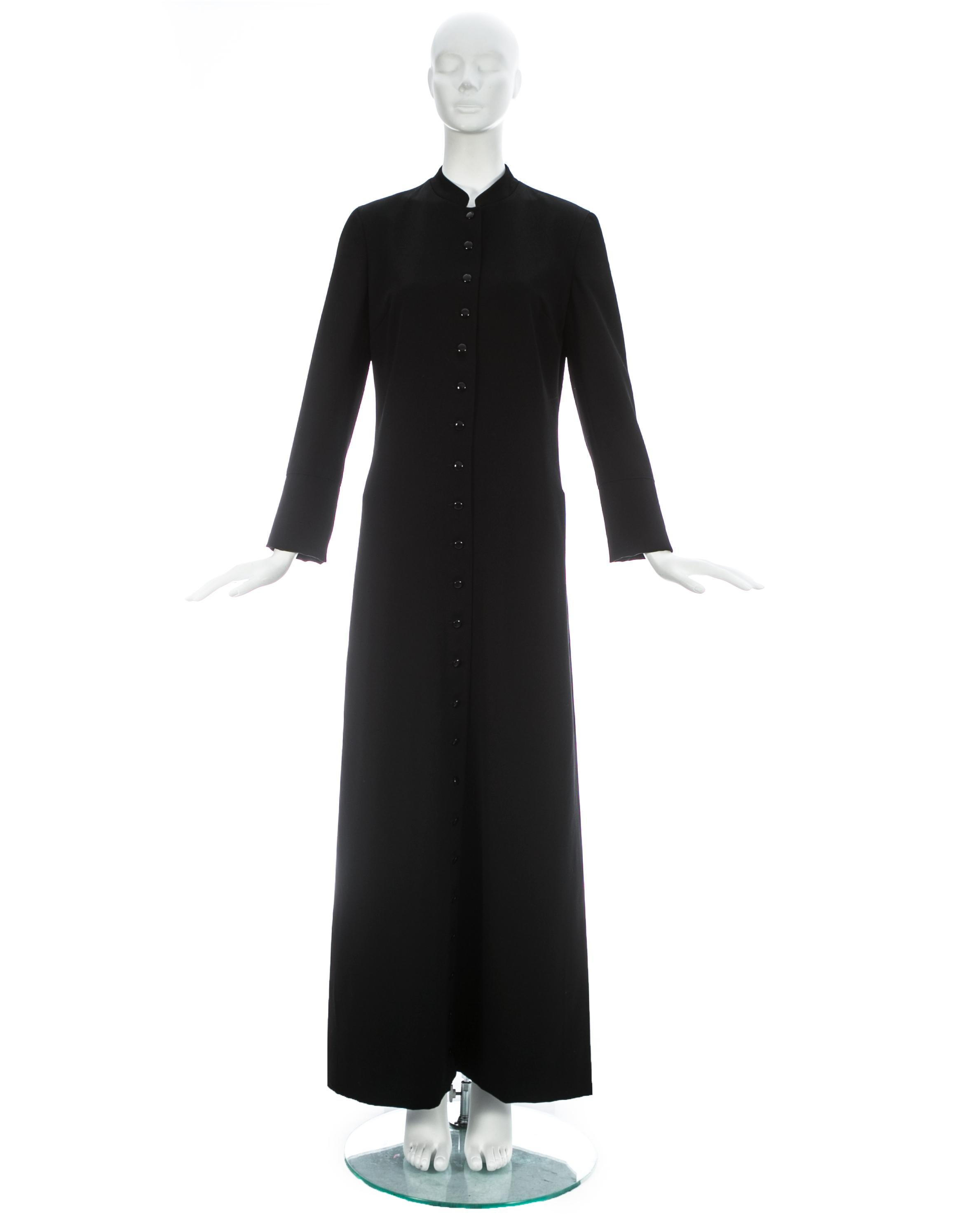 Dolce & Gabbana; Black wool full length priest coat with 23 button closures, 2 hidden side pockets, and red silk lining

Fall-Winter 1997