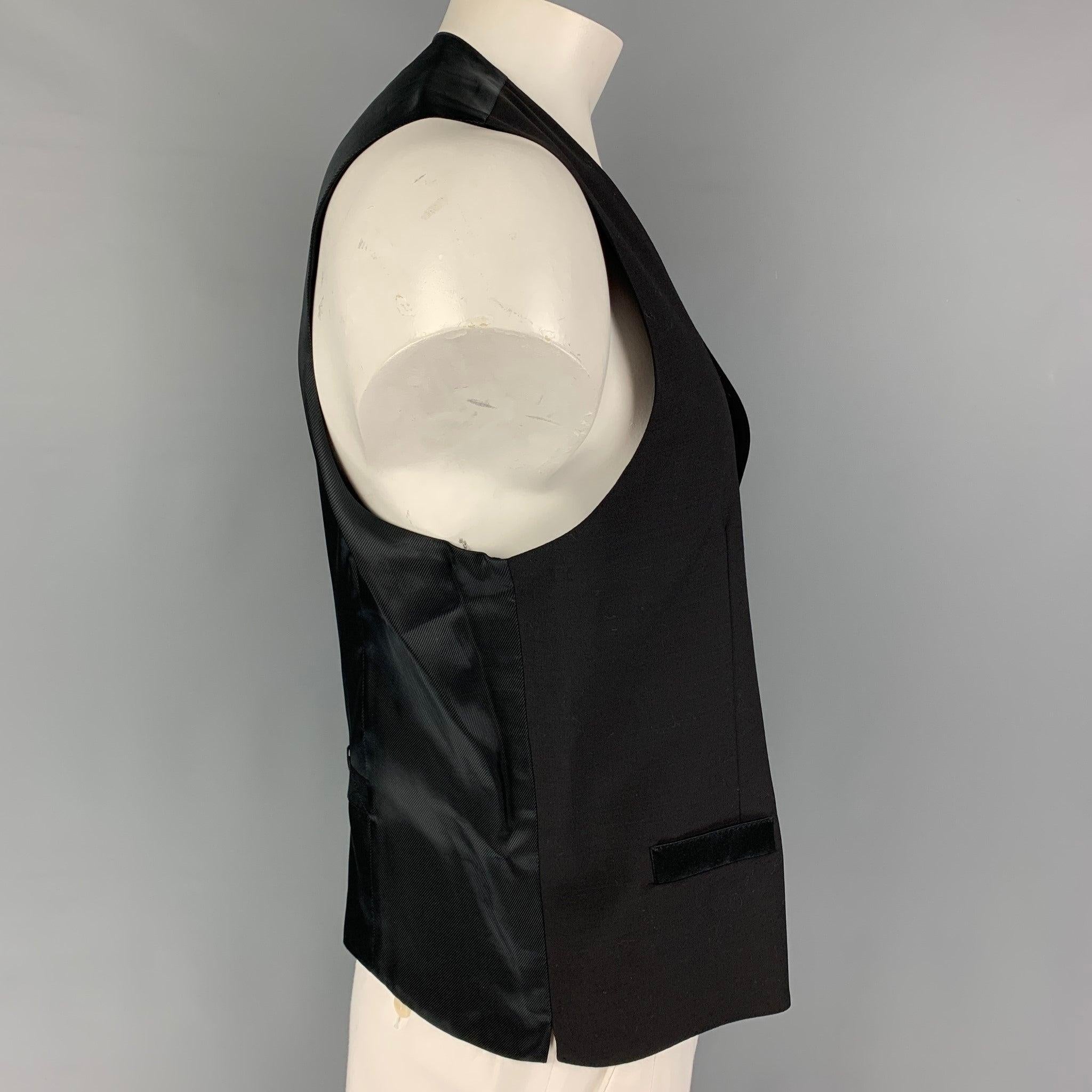 DOLCE & GABBANA vest comes in a black wool / silk featuring a back belt, slit pockets, and a buttoned closure. Made in Italy.
Very Good
Pre-Owned Condition. 

Marked:   56 

Measurements: 
 
Shoulder: 16 inches  Chest: 46 inches  Length: 25 inches