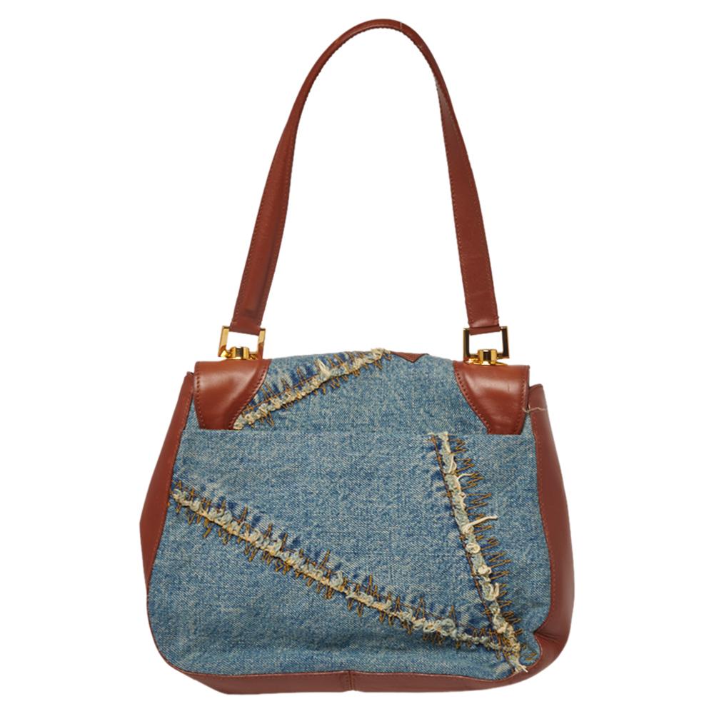 This chic, yet practical hobo by Dolce & Gabbana is a great casual handbag for daily use. The exterior is crafted from distressed denim and brown leather trim that is accented with a patchwork design and a buckle on the front flap. Its interior is