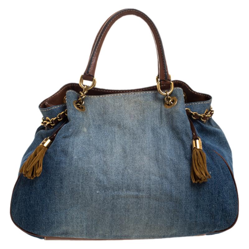 Crafted from denim and leather, this tote by Dolce & Gabbana is of perfect size. Its blue exterior is coupled with the brand plaque on the flap, chain details, double handles with studs and a leather base. Lined with fabric, the spacious interior