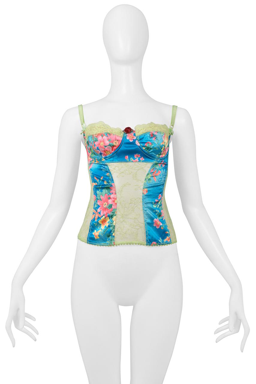 Resurrection Vintage is excited to offer a vintage Dolce & Gabbana blue top featuring a multicolor floral pattern, green lace panel insets, adjustable straps, back zipper closure, underwire in the bra cups, and a tiny rose made out of ribbon. From