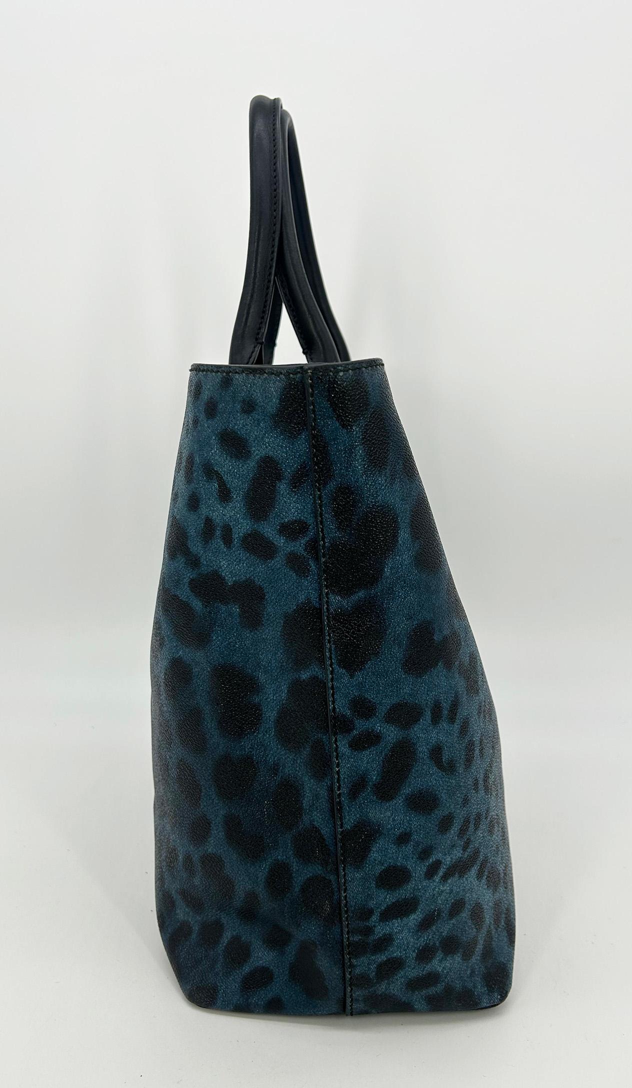 Dolce & Gabbana Blue Leopard Print Coated Canvas Tote en très bon état. Extérieur en toile enduite avec imprimé léopard exotique en bleu foncé et noir, avec quincaillerie dorée et poignées supérieures en cuir noir. La plaque d'identification gravée
