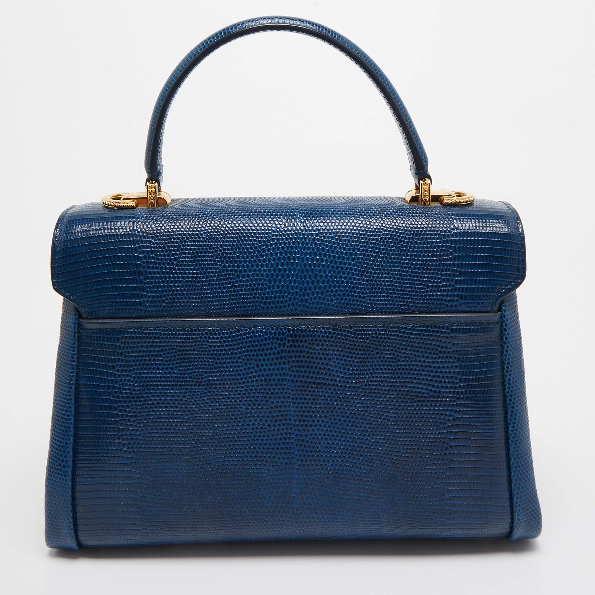 Ce sac Lucia de Dolce and Gabbana est le partenaire idéal pour les jours où vous n'avez besoin que de l'essentiel. Il est doté d'un superbe corps en cuir embossé de lézard et d'une bandoulière amovible. Il est orné d'une quincaillerie en métal doré