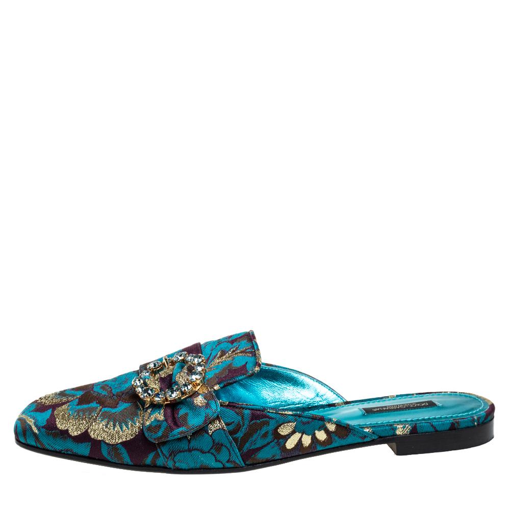 Crafted with utmost sophistication, these Dolce and Gabbana mules are a sight to behold! The blue mules have been crafted from printed brocade fabric into a rounded square toe silhouette and adorned with crystal-embellished buckle straps on the