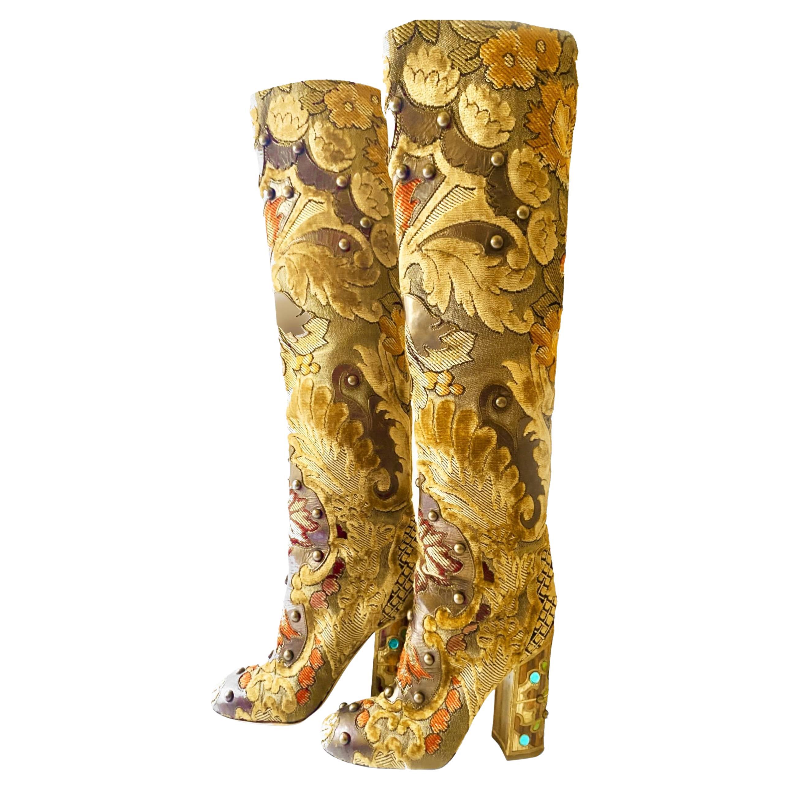 Dolce & Gabbana's Multicolor Brocade Fabric Over The Knee Boots boast a striking combination of beige velvet, brown leather, and intricate embellishments like stones and studs. The heel is adorned with artisanal wooden details, atop a leather