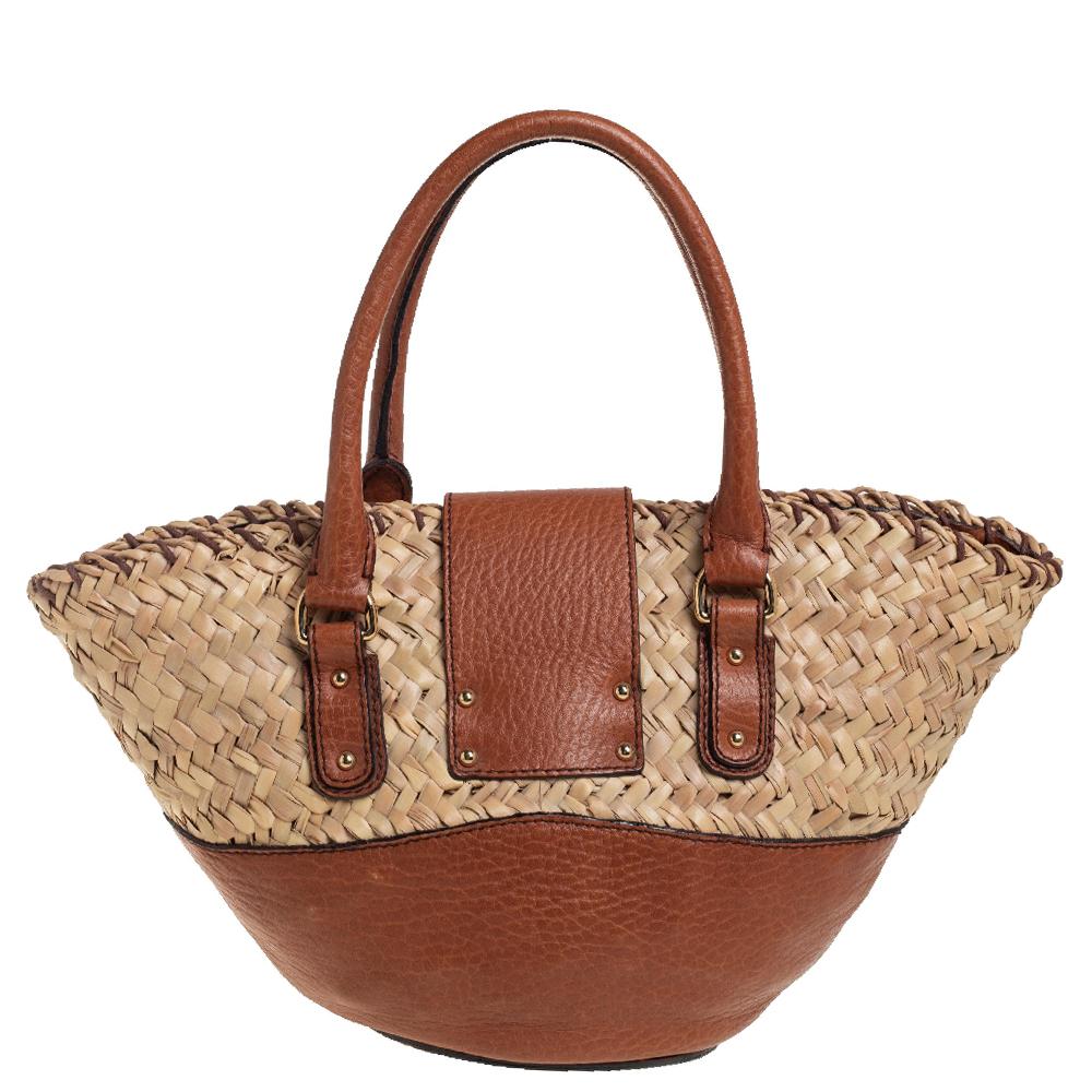 Carry this bag from the iconic house of Dolce & Gabbana without compromising on style. This super classy and stunning bag is crafted from woven raffia & leather and exudes brilliant craftsmanship. The brand name is flaunted on gold-tone metal detail