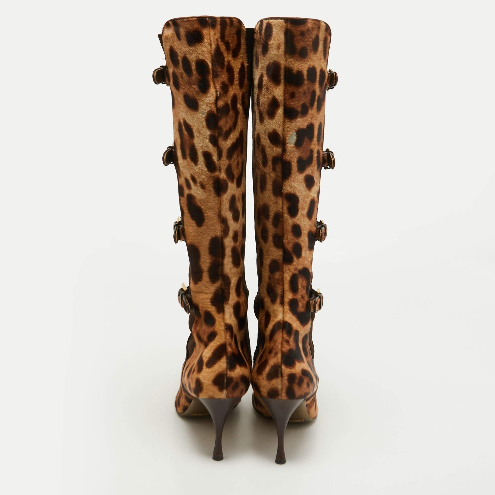 Verleihen Sie Ihrem Outfit ein schickes Update mit diesem Paar knielanger Stiefel von Dolce & Gabbana. Die Stiefel aus Kalbshaar mit Leopardenmuster haben überzogene Zehen, Schnallendetails und 9 cm hohe Absätze. Setzen Sie damit ein Zeichen!

