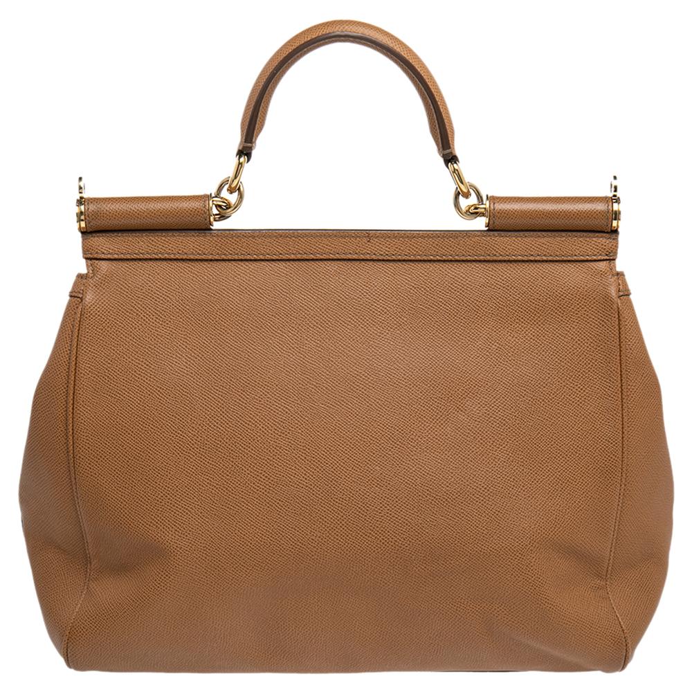 This gorgeous brown Miss Sicily bag from Dolce & Gabbana is a handbag coveted by women around the world. It has a well-structured design and a flap that opens to a compartment with fabric lining and enough space to fit your essentials. The bag comes