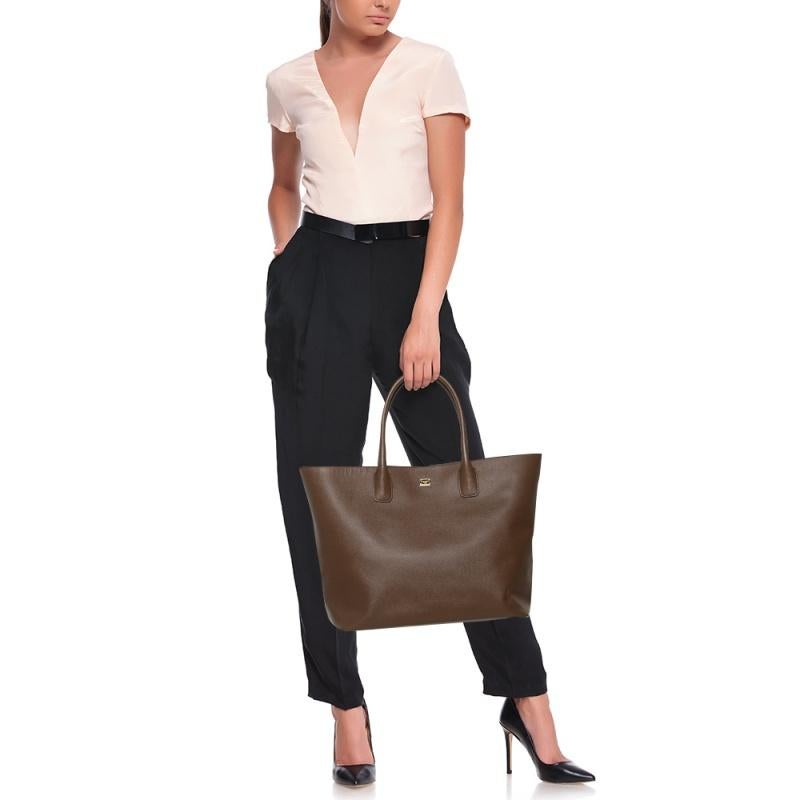 Flaunt your exclusive taste in fashion with this handbag from Dolce & Gabbana. Fashioned in leather, this bag makes an excellent addition to any stylish day edit. This chic bag has an equally divine interior lined with fabric. This impressive brown