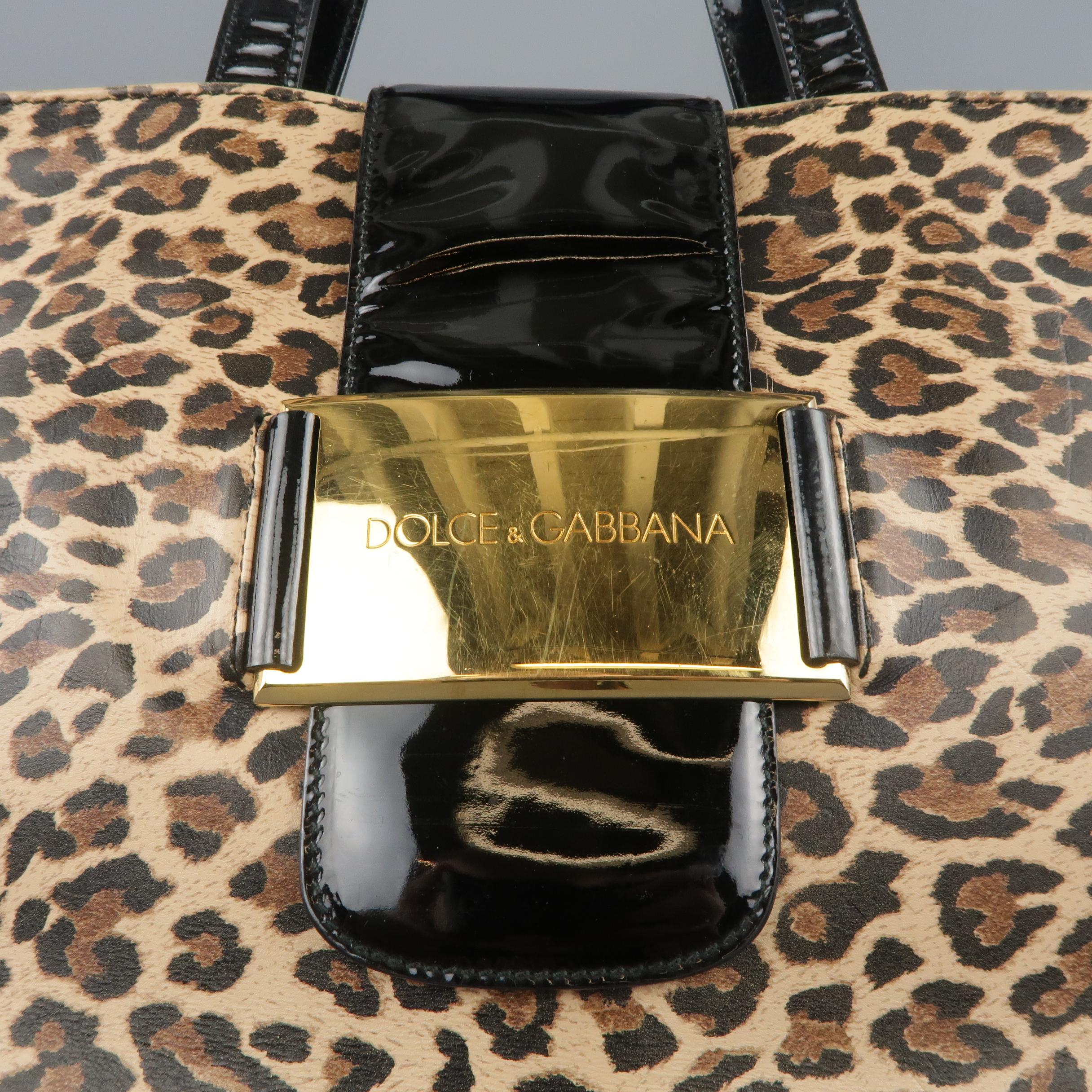 Vintage DOLE & GABBANA tote bag come sin animal print vinyl with black patent leather straps, a thick top strap closure with gold tone embossed metal plaque, and dual compartment interior with zip pocket divider. Wear throughout. Made in Italy.
