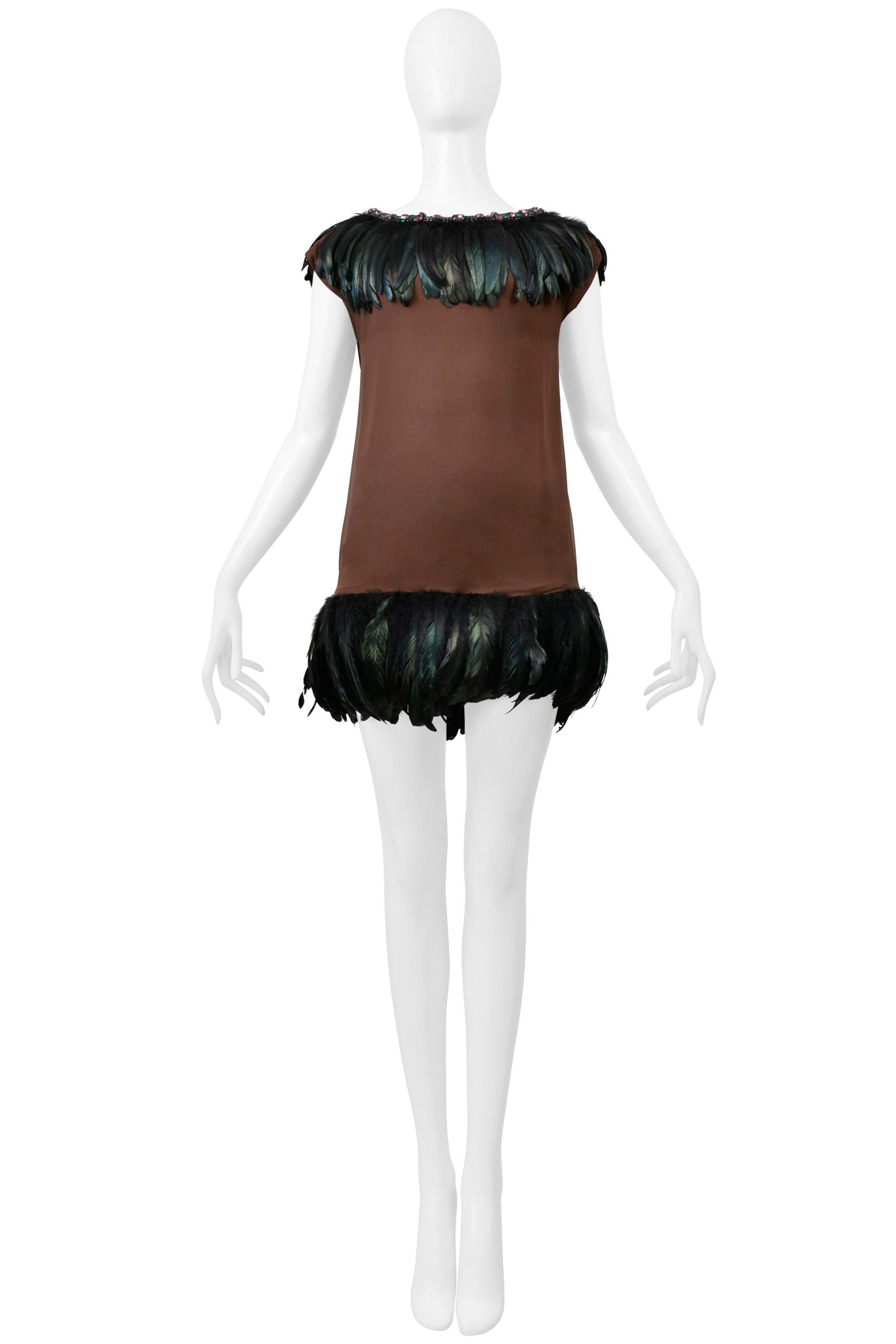 Resurrection Vintage is excited to offer a vintage Dolce & Gabbana brown mini dress featuring pink and green crystal rhinestones around the neckline, a collar of black feathers, a straight body, black feathers at the hem, and a side zipper