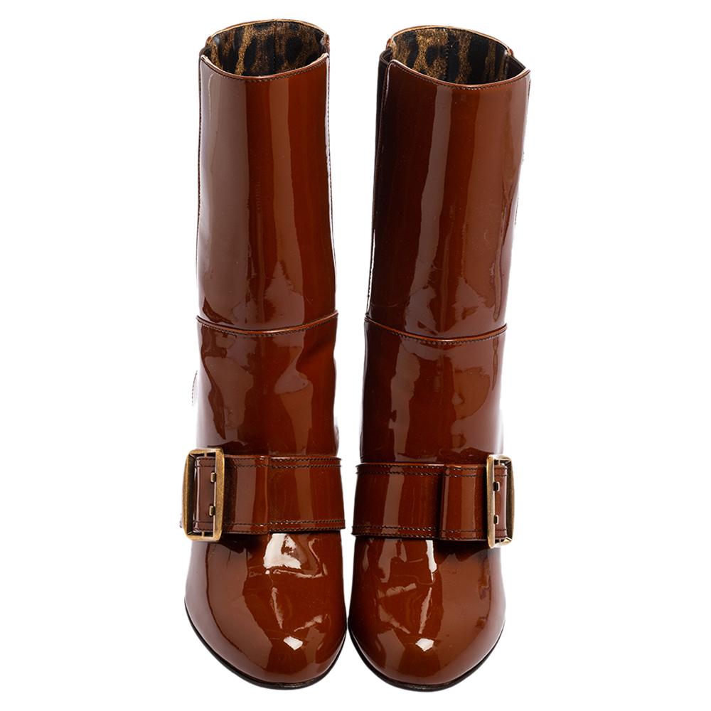 Let your winter styles look more mesmerizing and polished as you wear these super-trendy boots from Dolce & Gabbana. Crafted from brown patent leather, they are adorned with a gold-toned buckle detail on the upper, covered toes, and a mid-calf