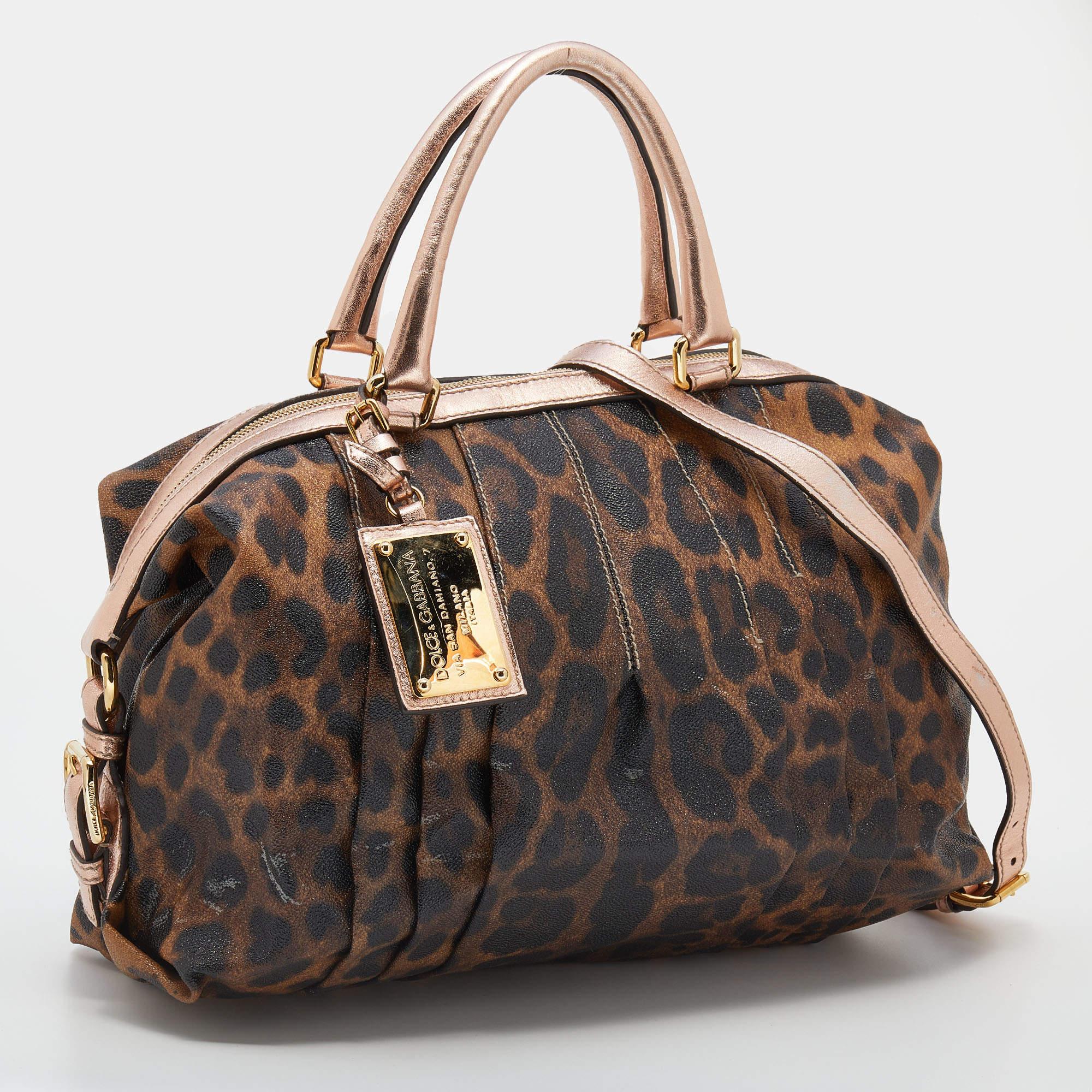 Cette sacoche de Dolce & Gabbana est à la fois élégante et fonctionnelle. Confectionné en toile et cuir imprimés léopard marron-rose, ce sac est doté de deux anses supérieures et de ferrures dorées. L'intérieur doublé de toile offre suffisamment
