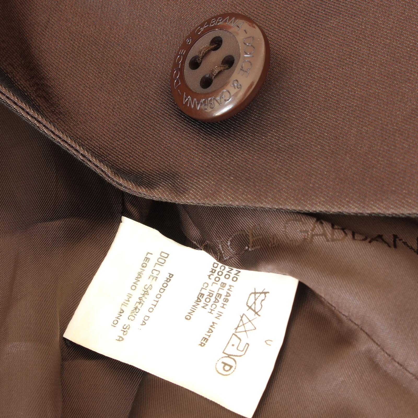 Dolce & Gabbana, this 2000s skirt suit is made of 100% silk, for luxurious comfort and style. The classic brown color adds a touch of sophistication to the fitted jacket and sheath short skirt, perfect for any occasion. Elevate your wardrobe with