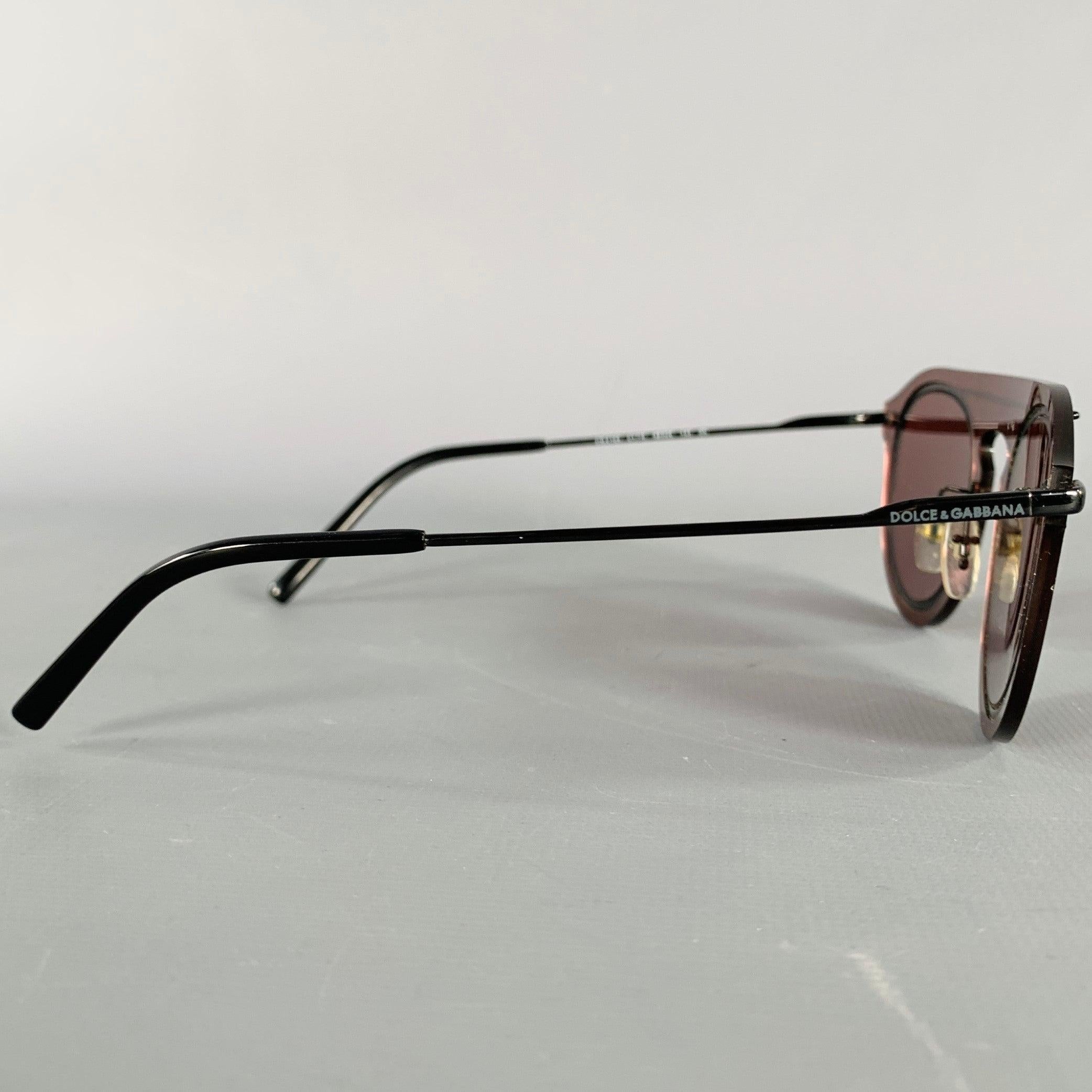 DOLCE & GABBANA sunglasses
in a minimal black acetate featuring tinted burgundy rimless illusion lenses. Comes with case. Made in Italy.Very Good Pre-Owned Condition. 

Marked:   DG2169  

Measurements: 
  Frame Width: 14.25 cm.Frame Height: 4.5 cm.
