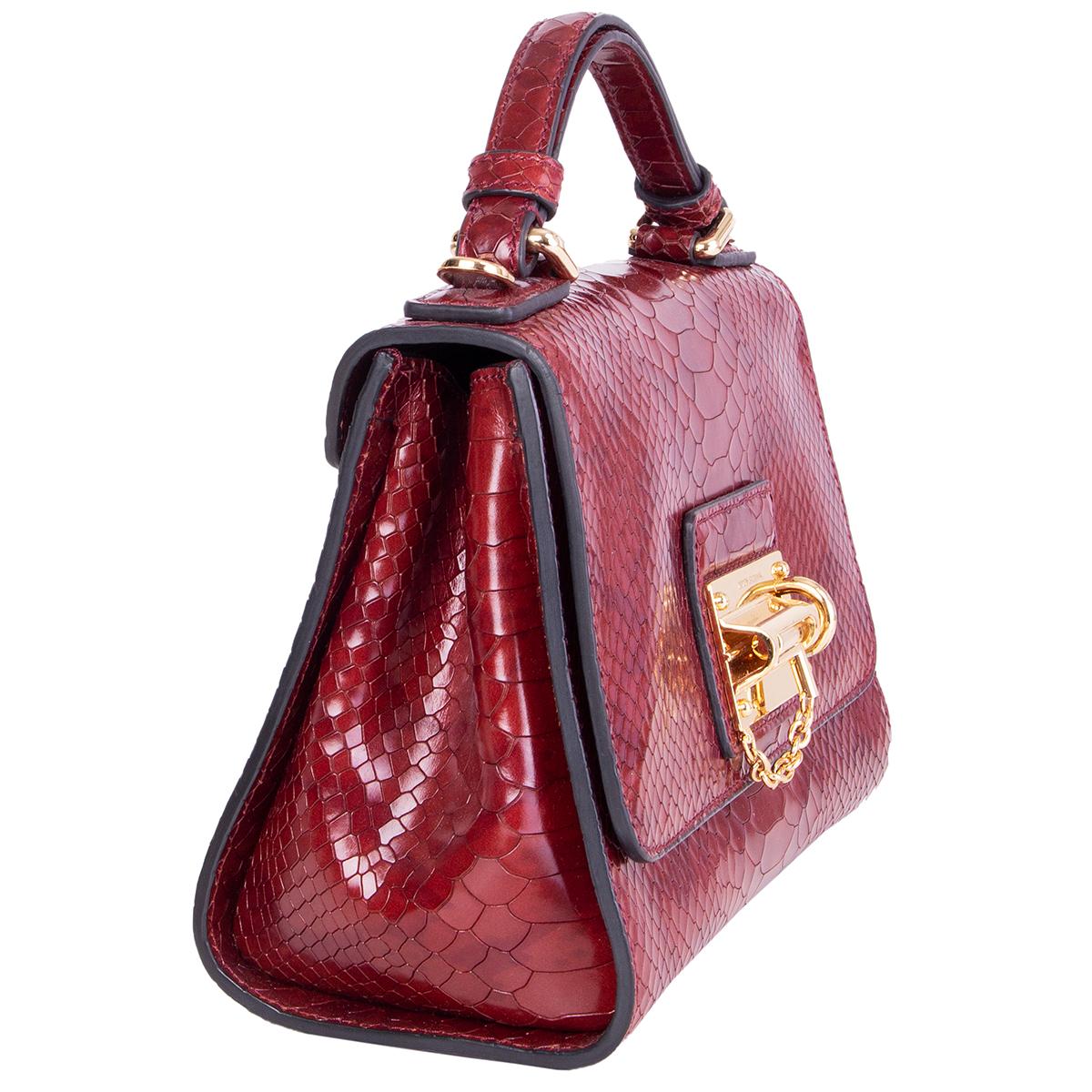 Dolce & Gabbana Monica Small shoulder bag in burgundy python embossed calfskin. Opens with a flap lock closure that is adorned with a gold-tone bar latch-lock. Lined in burgundy calfskin and leopard print canvas with one open pocket against the