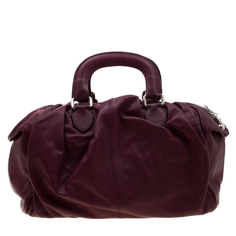 This Miss Curly bag by Dolce & Gabbana is a piece all fashionistas must look out for! Meticulously crafted from leather, it features a burgundy shade and kiss lock pockets on the front. The bag is equipped with a spacious fabric interior and is held