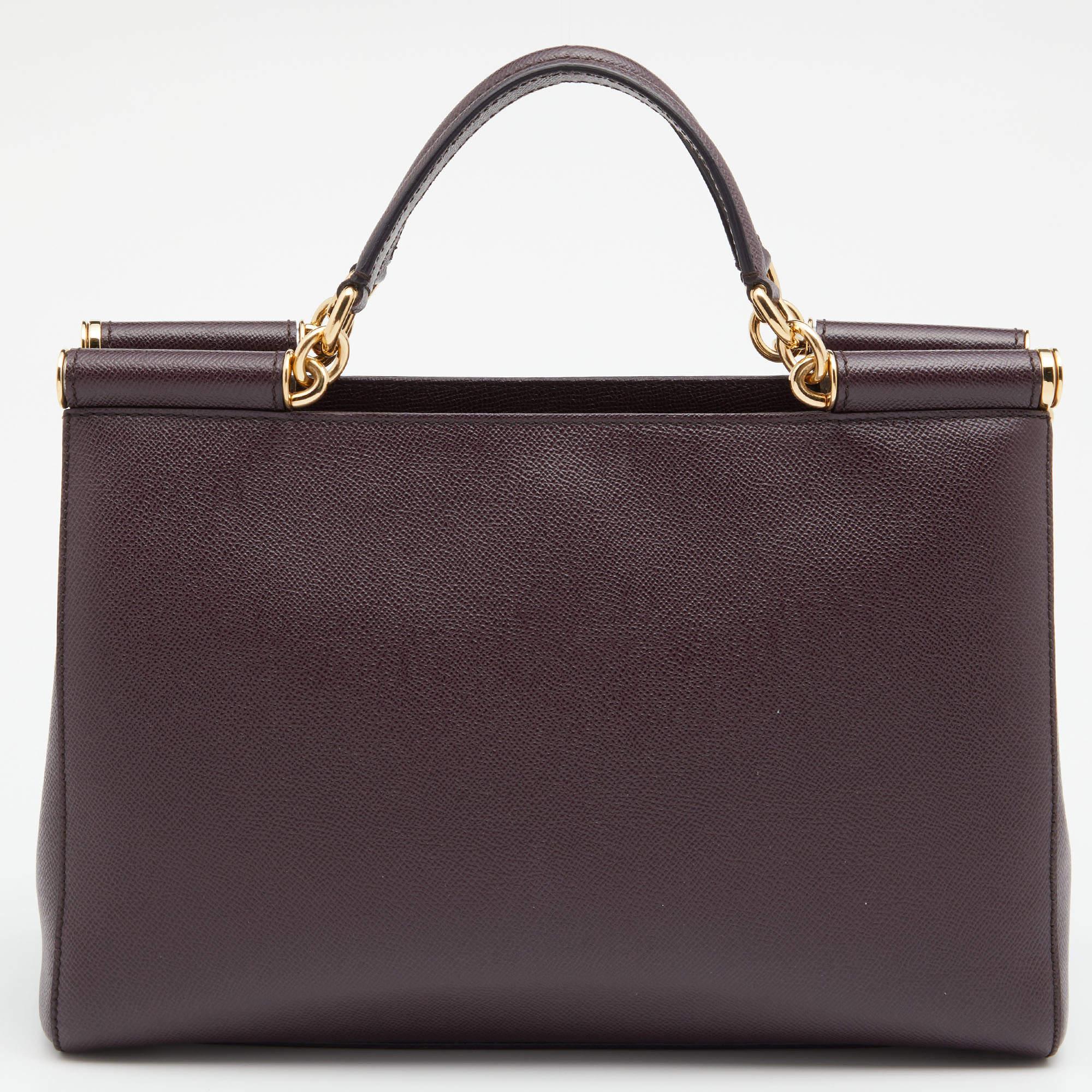 The elegant silhouette of this Dolce & Gabbana bag is made from burgundy leather and complemented by gold-tone hardware. Parade it by the top handle or shoulder strap.

Includes: Original Dustbag, Info Booklet, Authenticity Card, Mirror