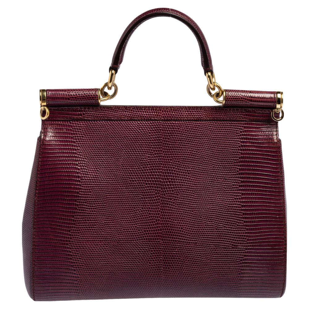 The Miss Sicily bag by Dolce & Gabbana is one of the most loved designs from the brand. The elegant silhouette is made from lizard-embossed leather in a grey shade and features a front flap closure. The creation is complemented with gold-tone