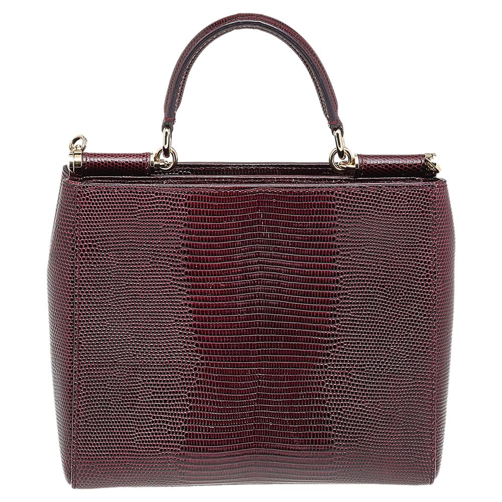 This gorgeous burgundy Miss Sicily from Dolce & Gabbana is a handbag coveted by women around the world. It has been crafted from lizard-embossed leather. It has a well-structured design and opens to a compartment with fabric lining and enough space