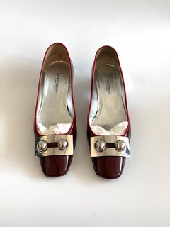 Dolce & Gabbana Pumps aus burgunderrotem Lackleder mit niedrigem Absatz und silbernen Metallbeschlägen