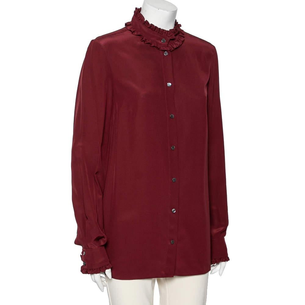 Make a classy style statement by wearing this chic shirt from the House of Dolce & Gabbana. It is tailored using burgundy silk fabric, with ruffled trims enhancing its silhouette. It has a button-front feature and long sleeves. This shirt can be
