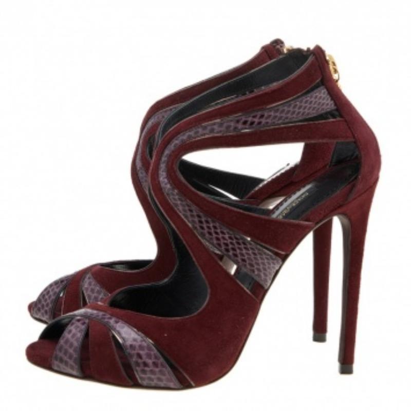 The employment of snakeskin leather in their construction makes these Dolce & Gabbana sandals valuable. Made from suede as well, they flaunt asymmetric cut of the straps, gold-tone hardware, and 11.5cm heels. The zipper closure at the counter adds