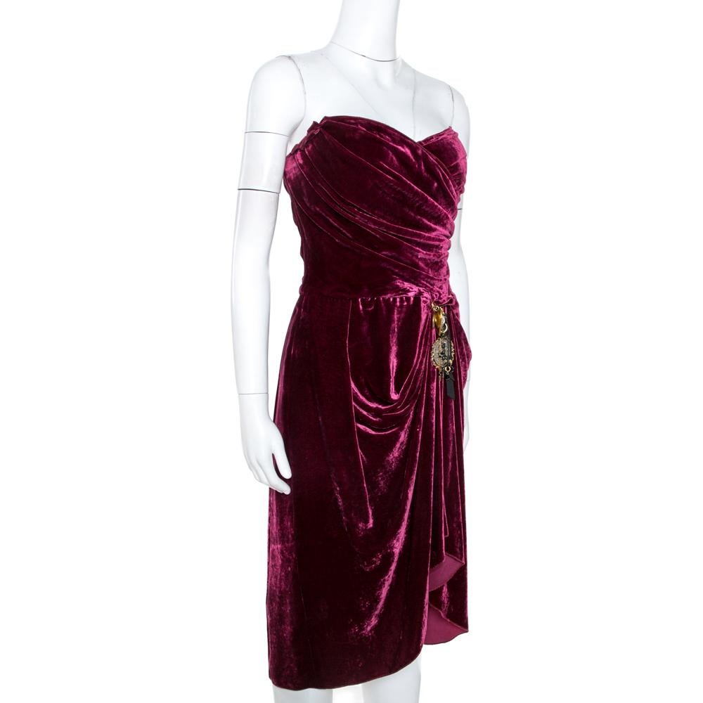From Dolce & Gabbana's Fall 2010 Ready-To-Wear collection, this dress brings a wave of elegant charm. It comes in velvet with details of drapes and a dangling charm that is detachable. The dress in burgundy is a runway dream that can be yours.

