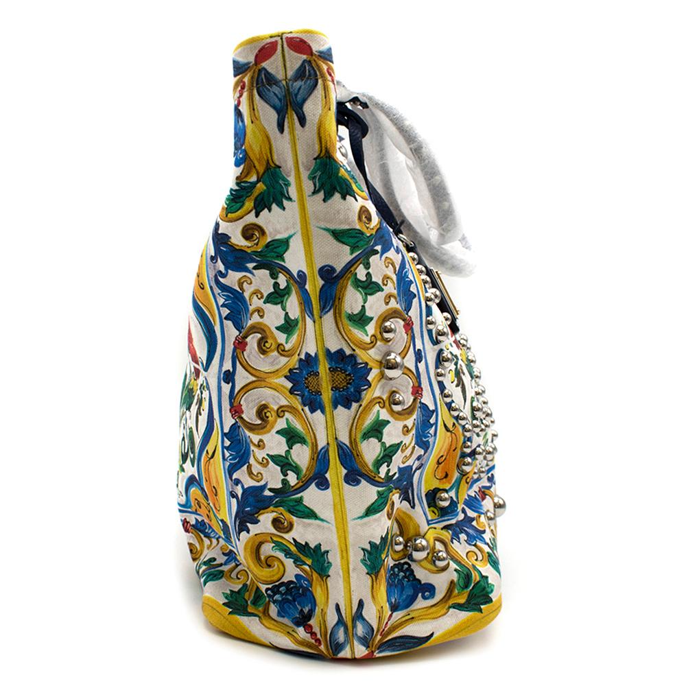 Dolce & Gabbana Canvas Majolica Print Shopping Tote

- Blue leather top handle 
- Design inspired by Maiolica 
- Silver studs on the front 
- Magnetic clasp 
- Zip pocket and two buttoned pockets 

Please note, these items are pre-owned and may show